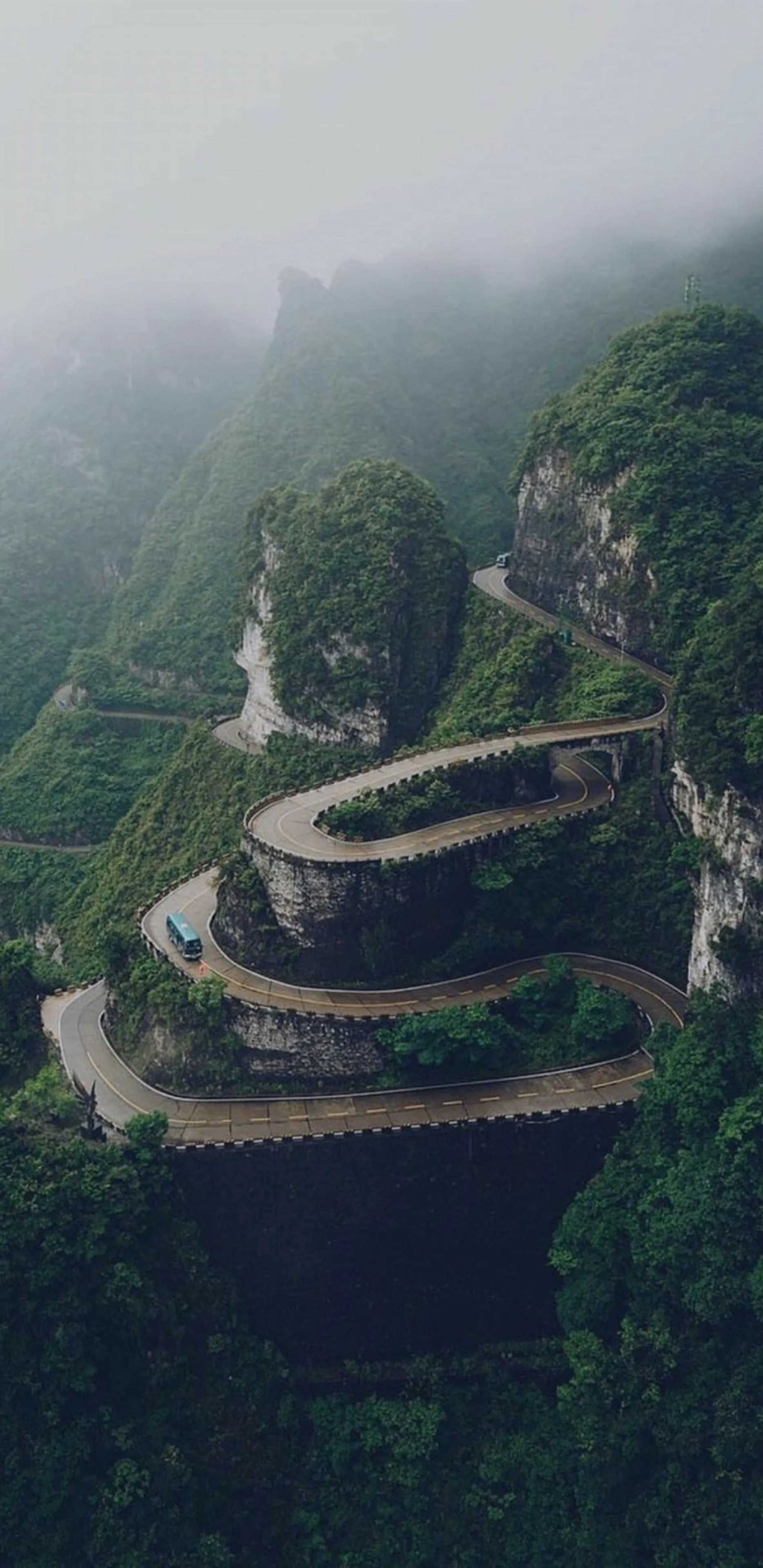 Serene Mountain Road Winding Through The Hills Wallpaper