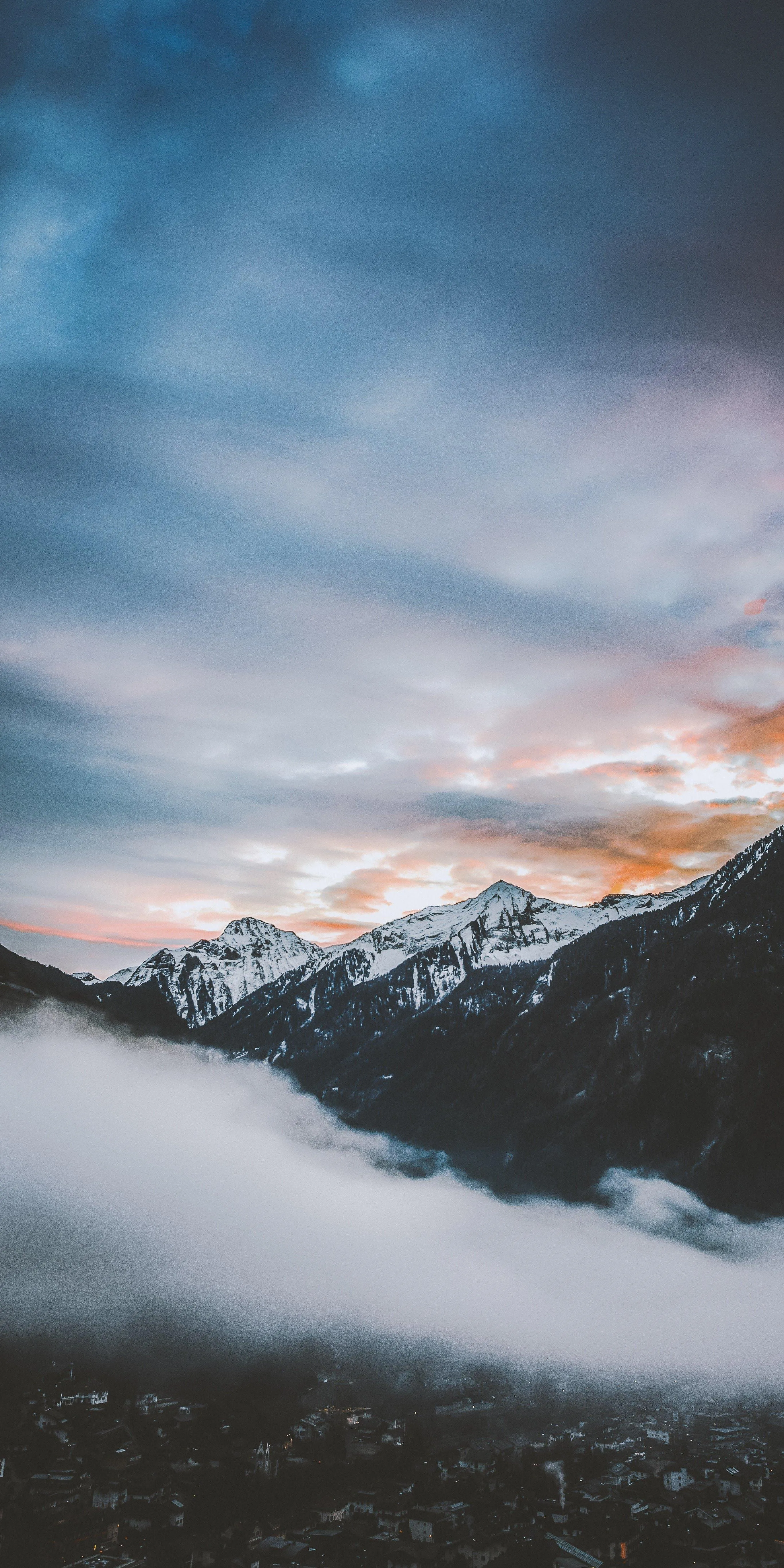 Serene Mountain View with Mist and Colorful Sky Image