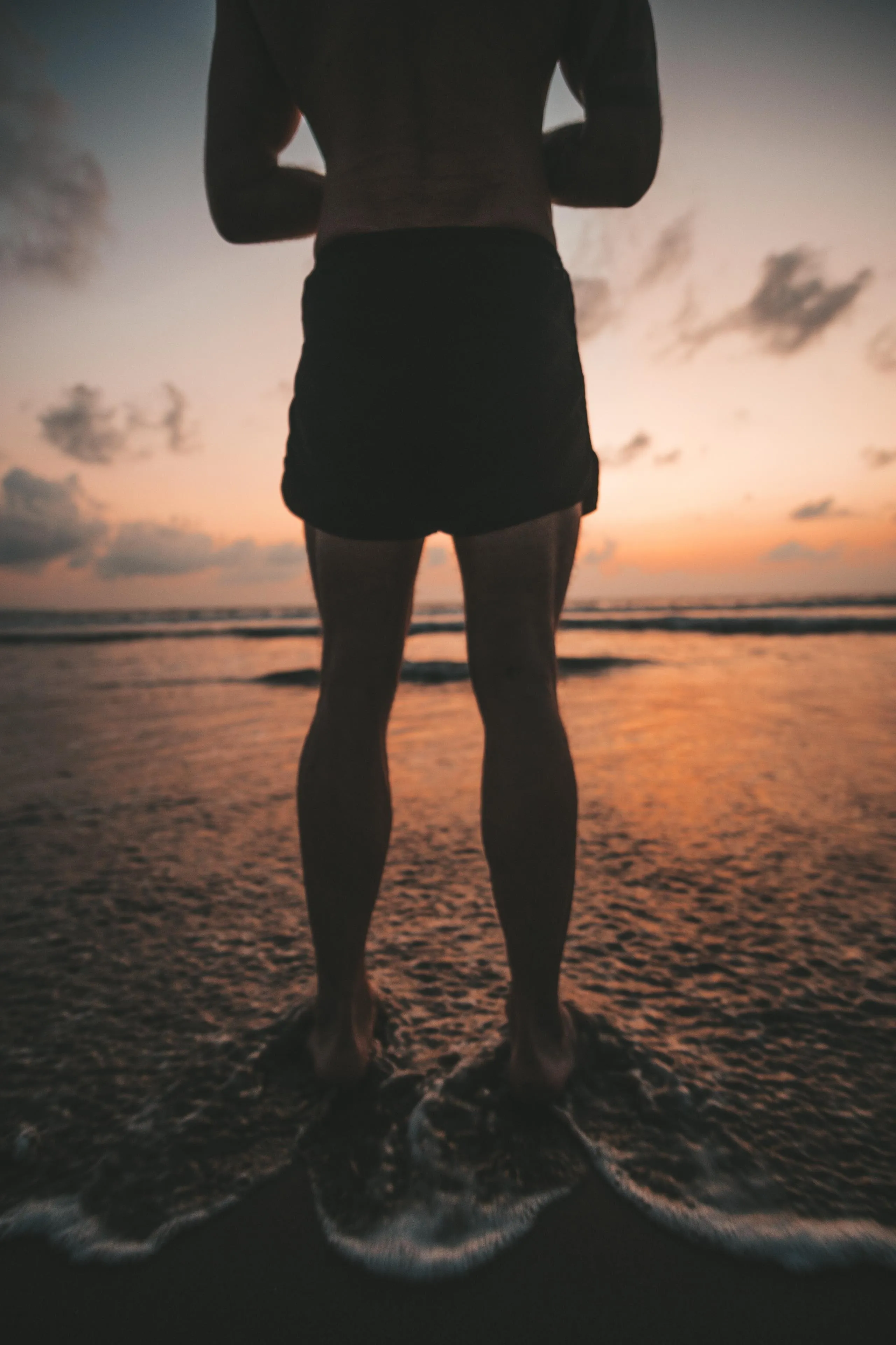 Silhouette of Person Standing on Shore During Golden Hour