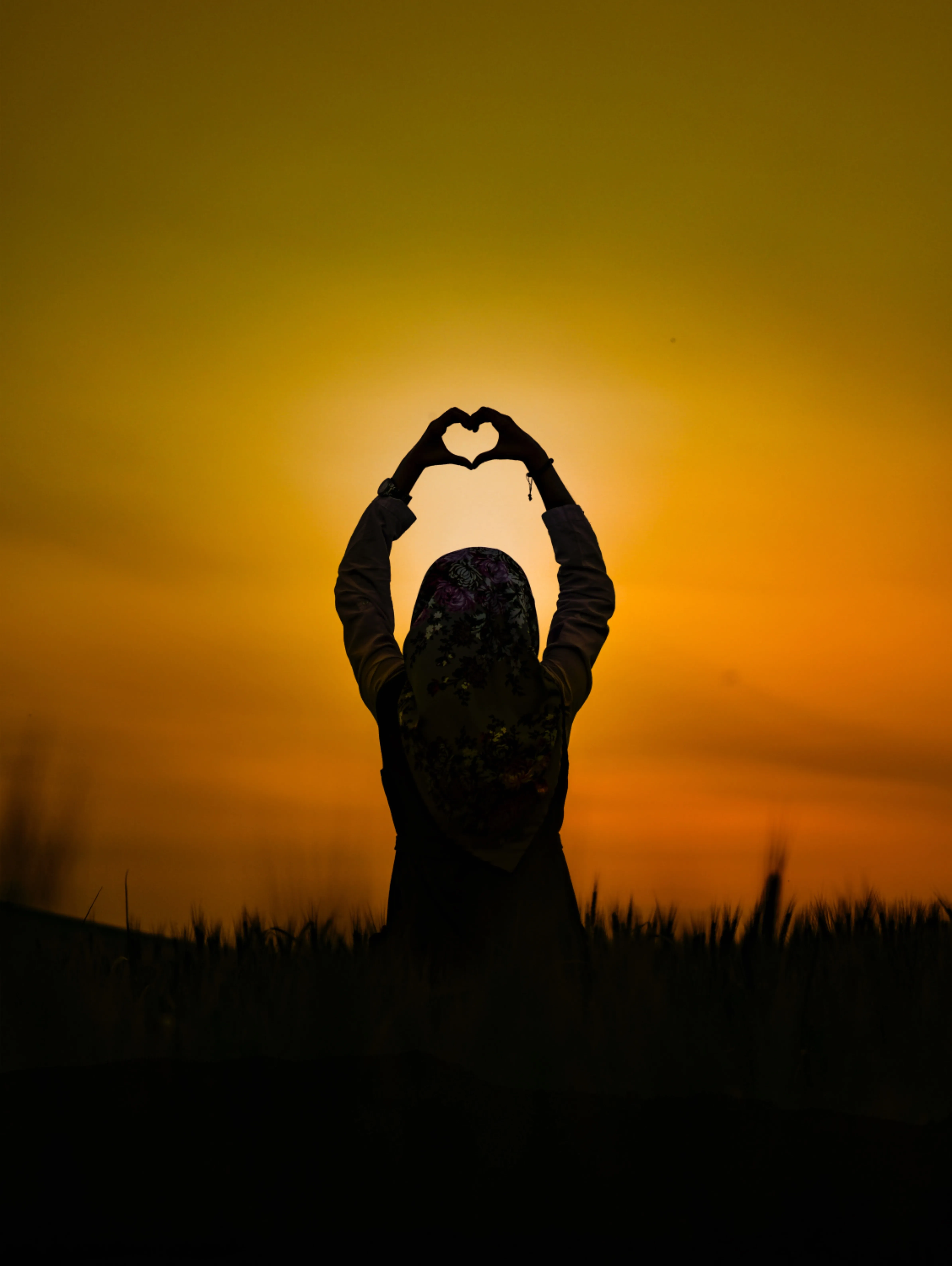 Silhouette of Woman at Sunset in Heart Pose Wallpaper