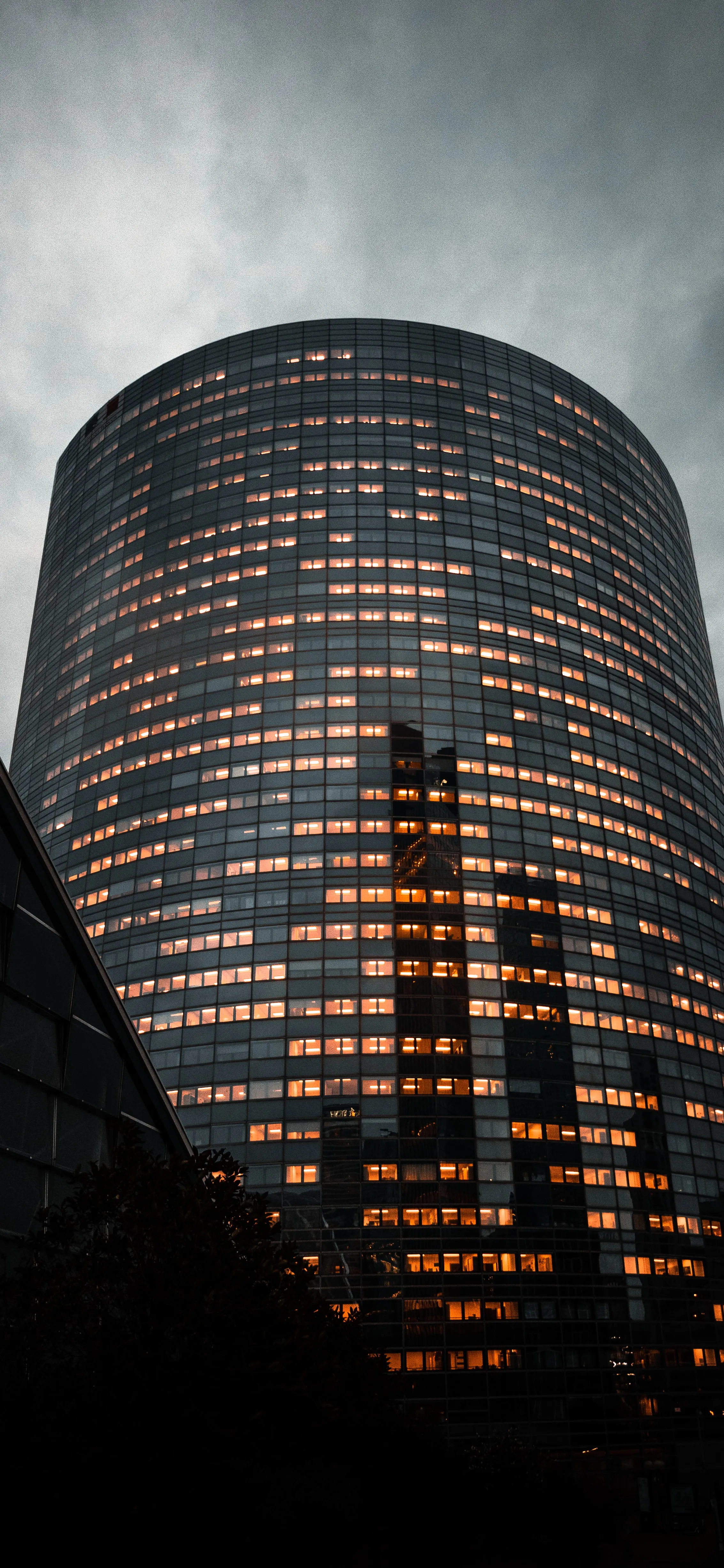 Skyscraper Lit from Inside Against a Moody Sky View