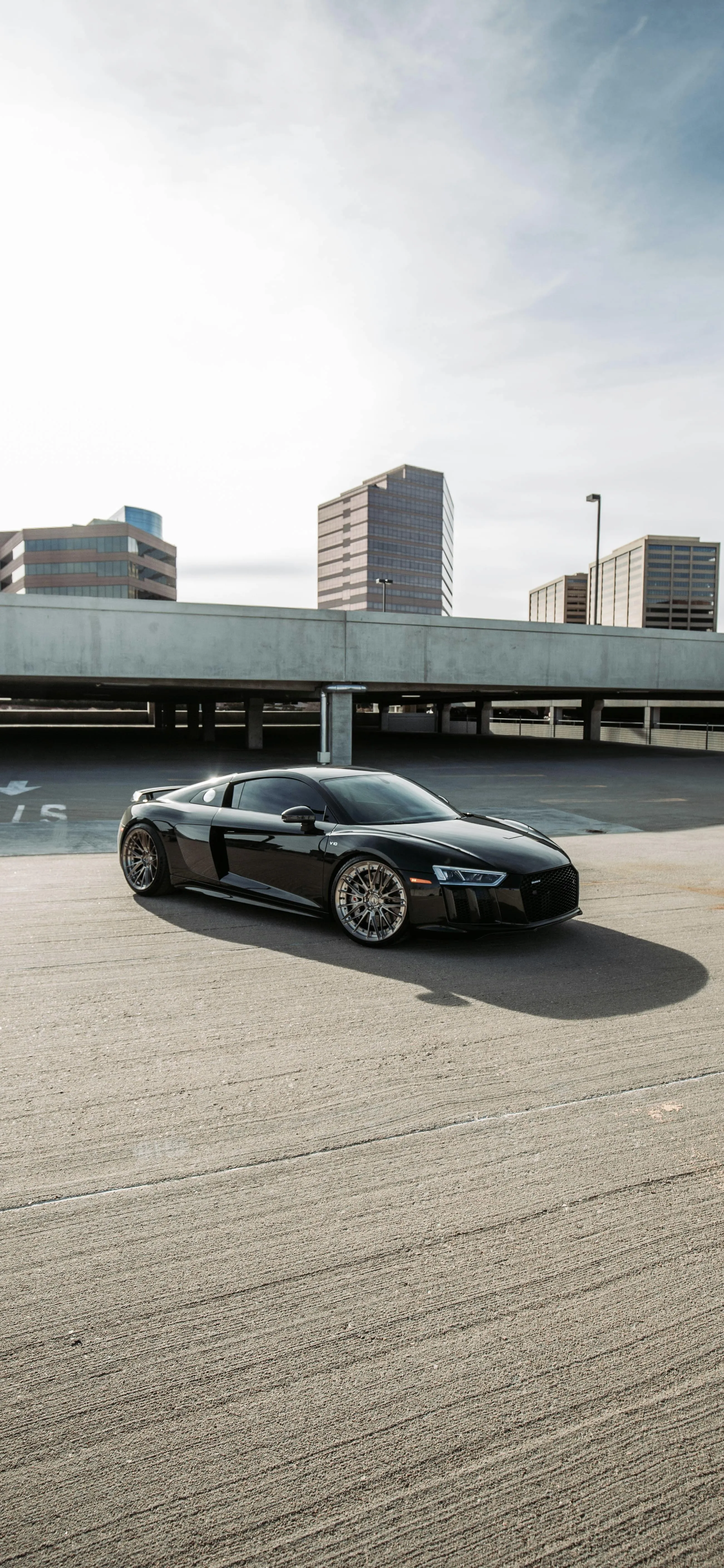 Sleek Black Sports Car in Urban City Street Background