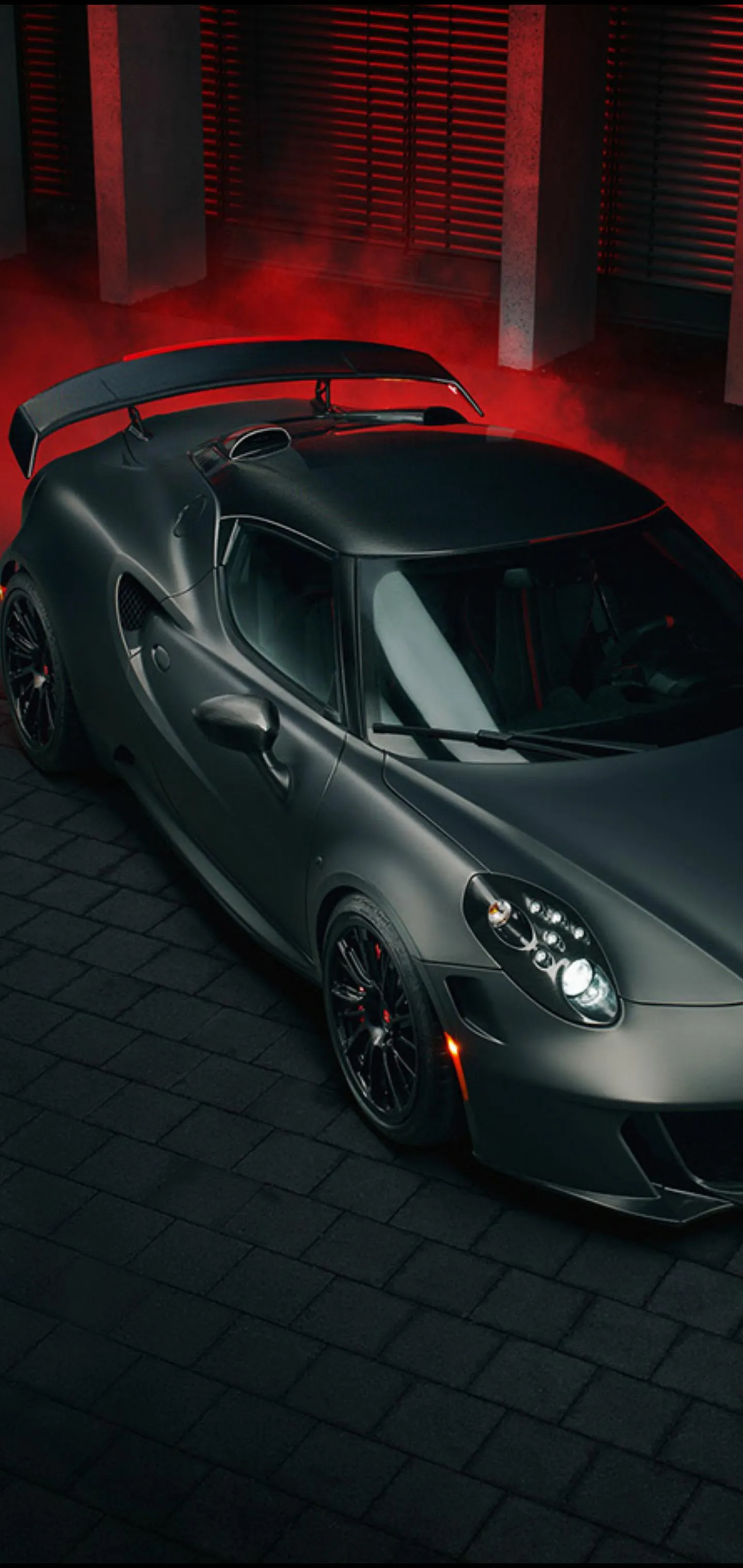 Sleek Black Sports Car with Red Light Reflections Wallpaper