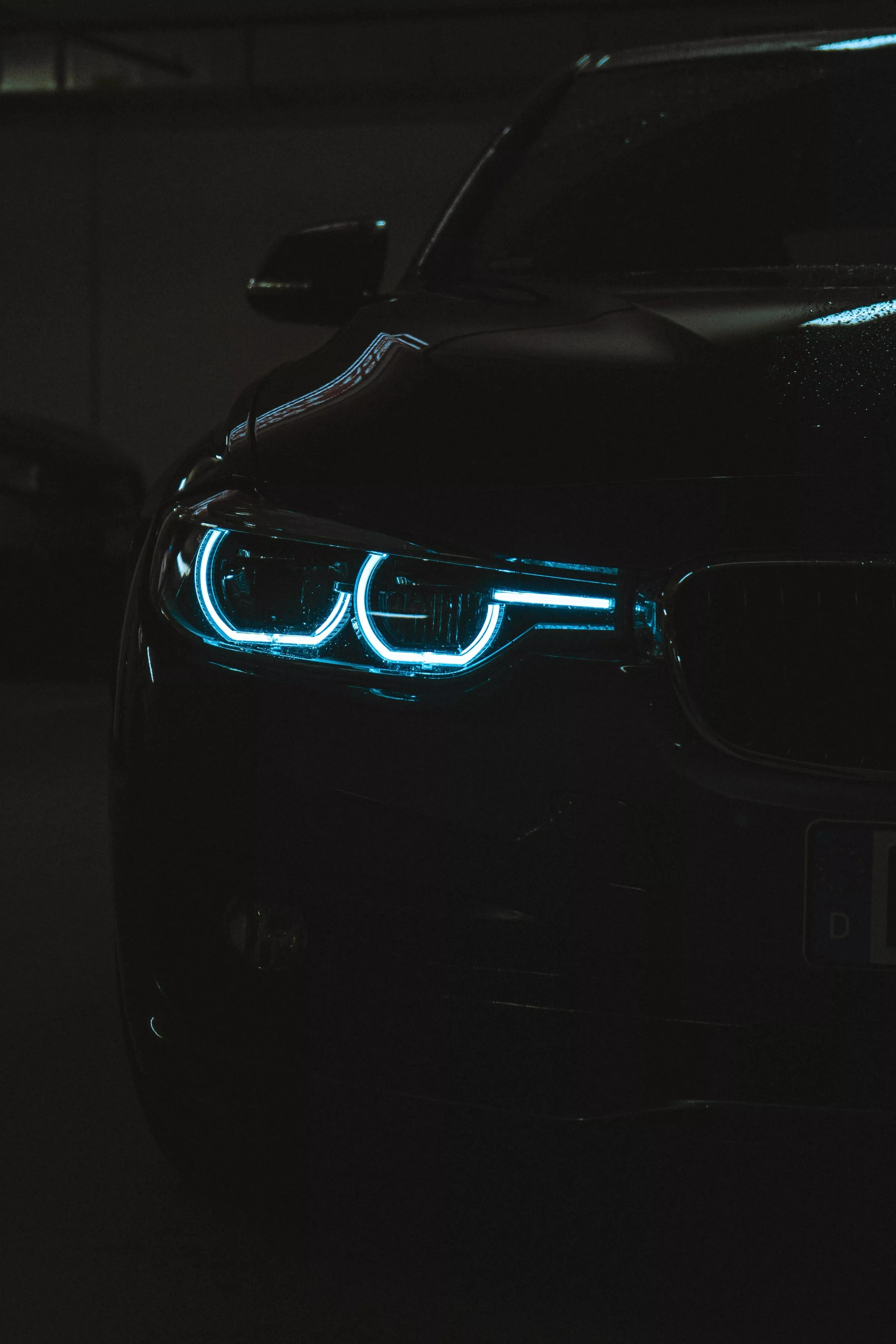 Sleek Luxury Car Headlights Glowing in a Dark Night View