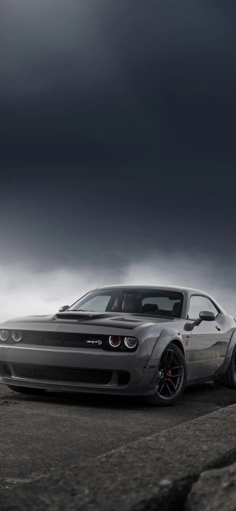 Sleek White Sports Car Under Cloudy Evening Sky Wallpaper