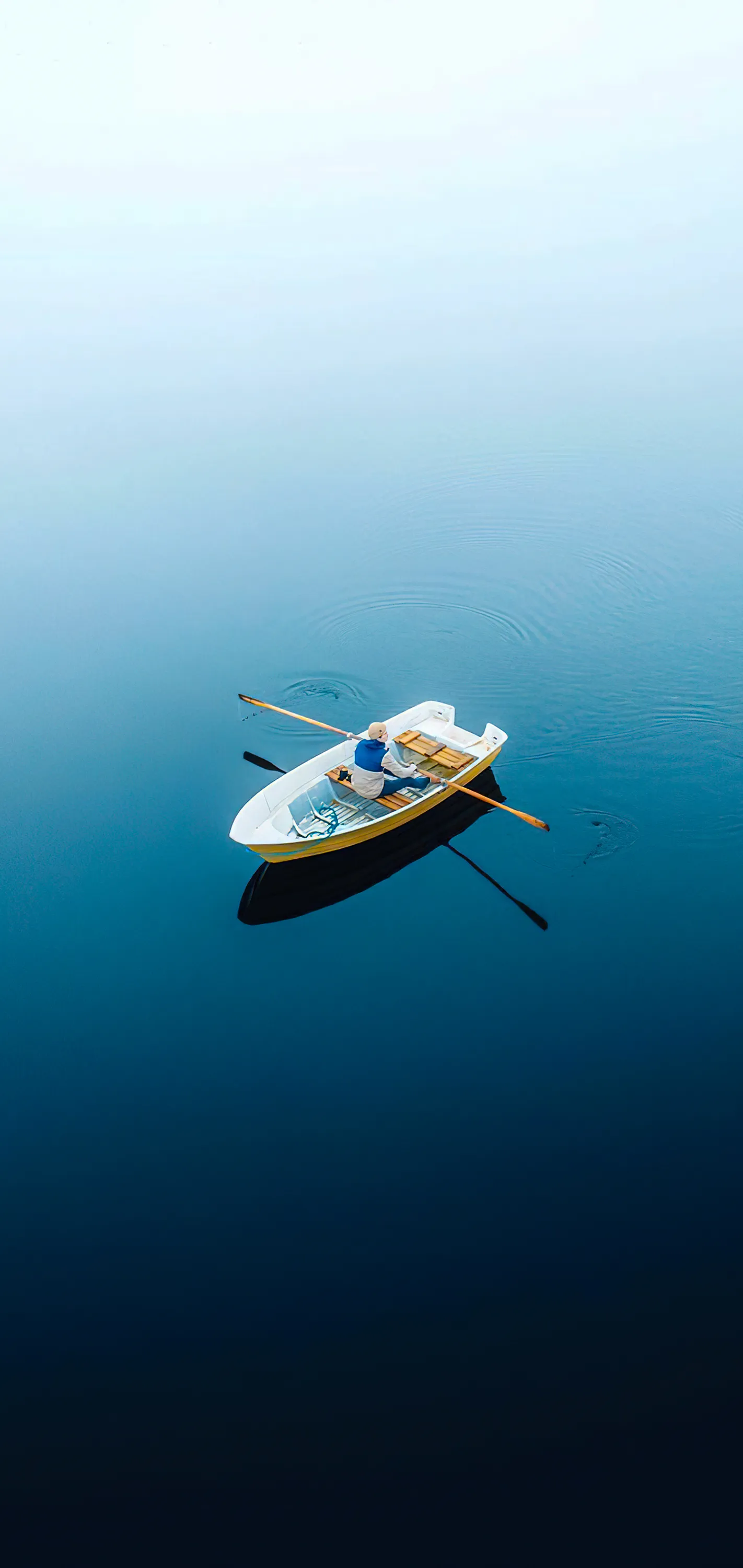 Small Boat Floating on Deep Blue Ocean Water Wallpaper