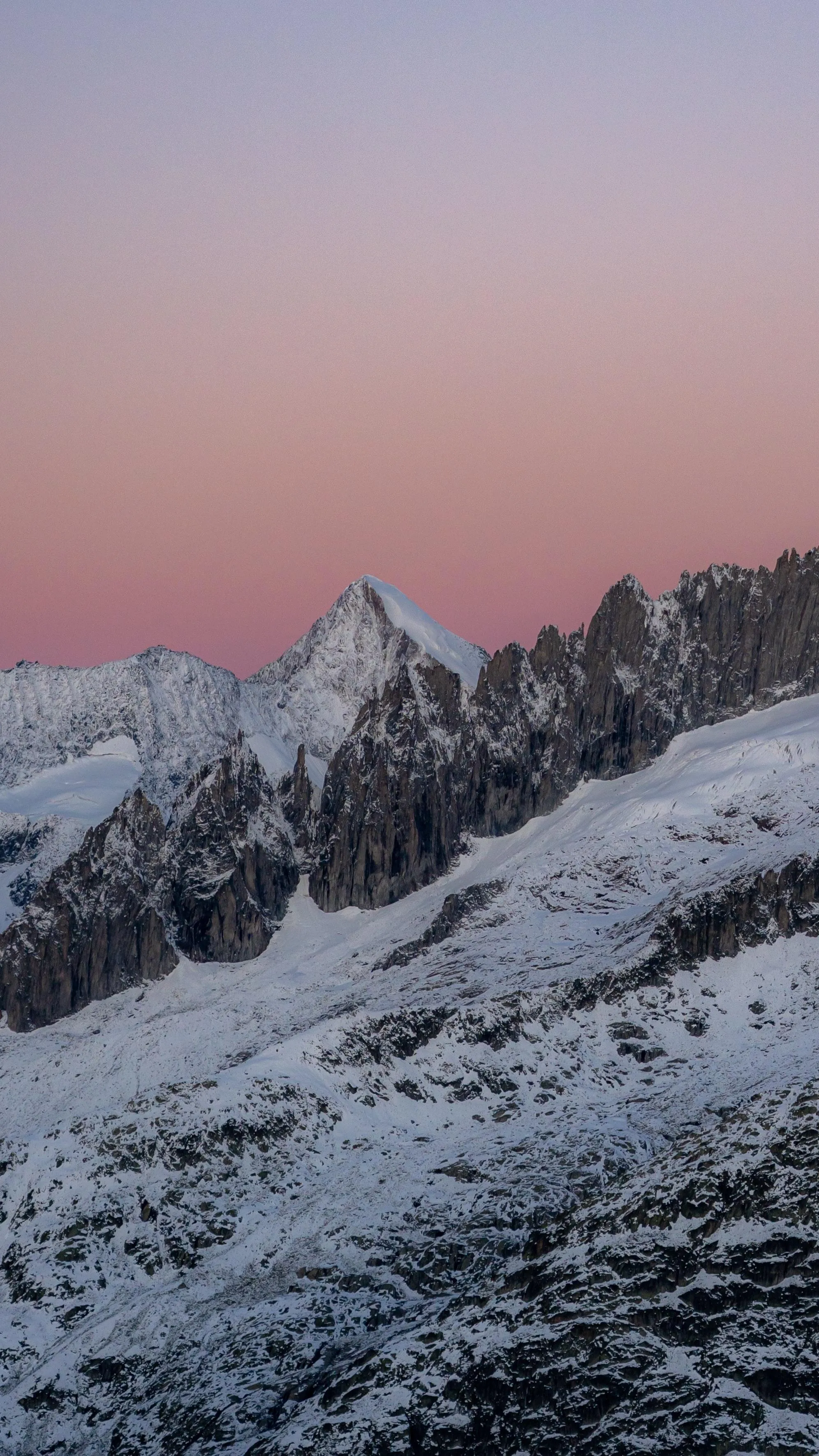 Snowy Mountain Peaks Under Warm Calm Evening Sky Image