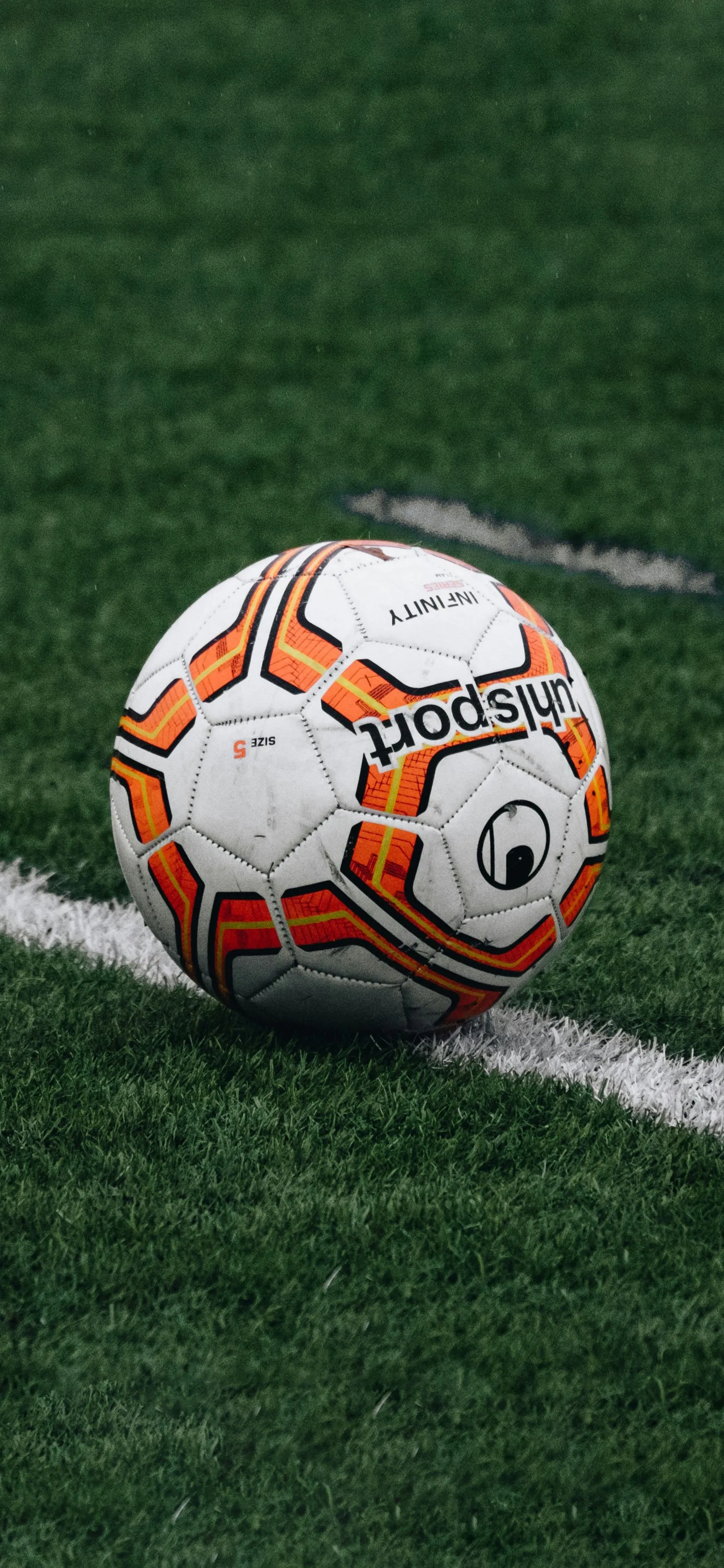 Soccer Ball Resting on Fresh Green Grass Field Wallpaper
