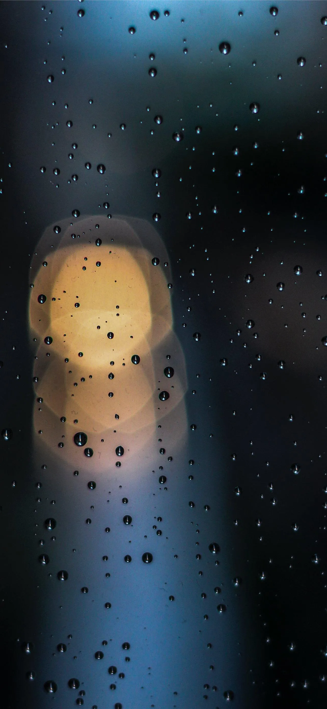 Soft Raindrops on Glass with Warm Blurred City Light Glow