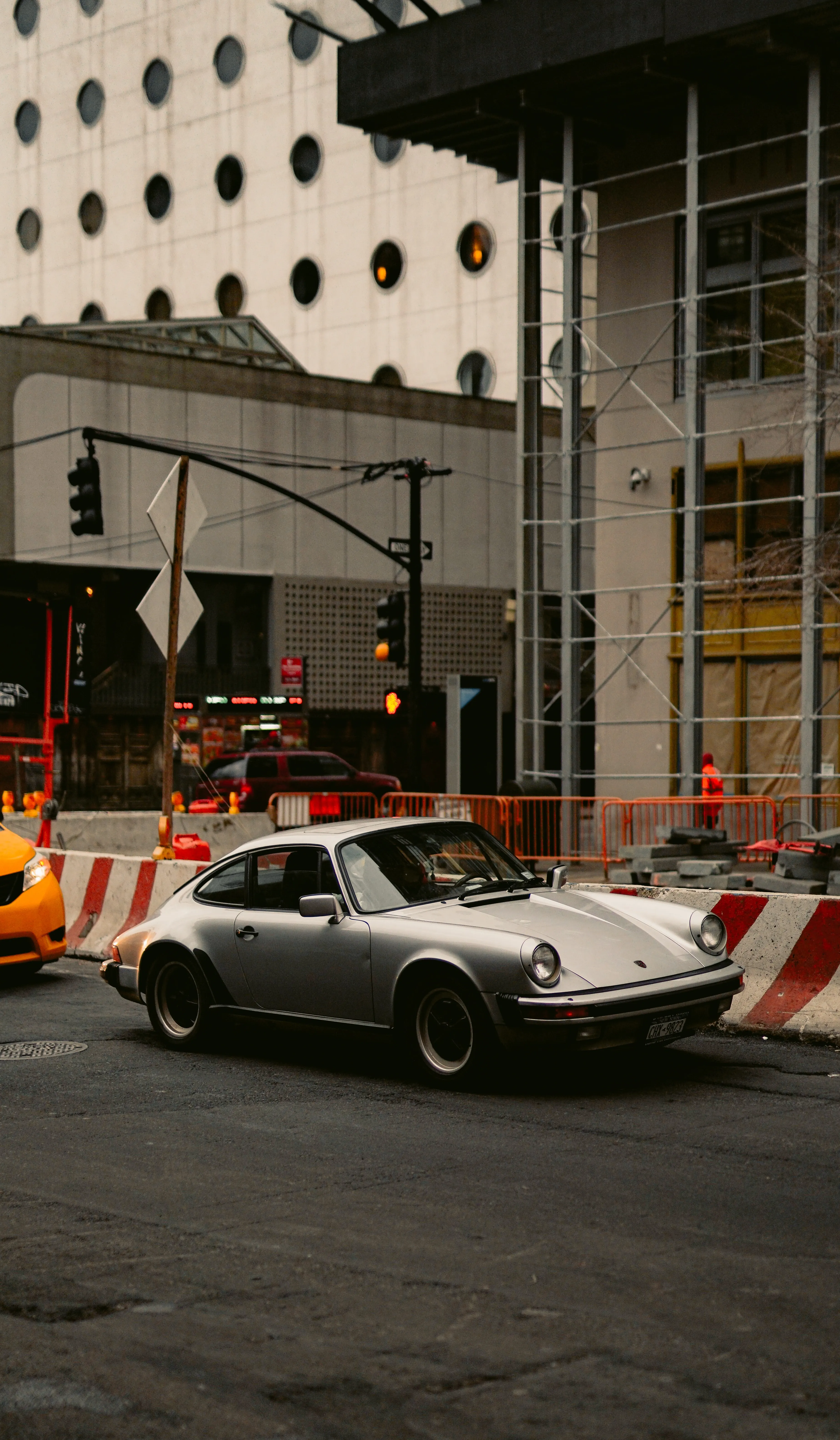 Sports Car Driving Past Urban Construction at Night