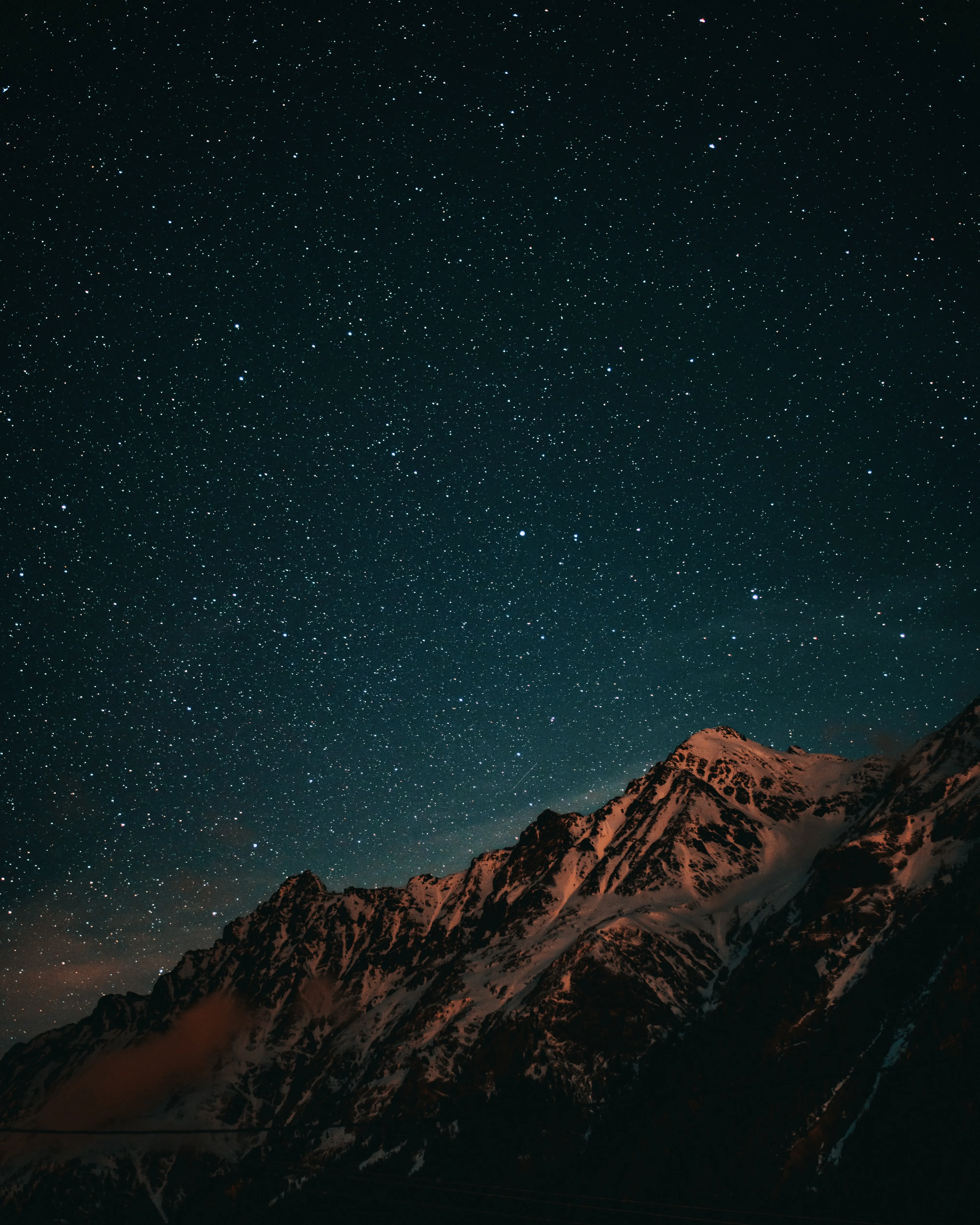 Starry Night Sky Over Majestic Mountain Peak Wallpaper