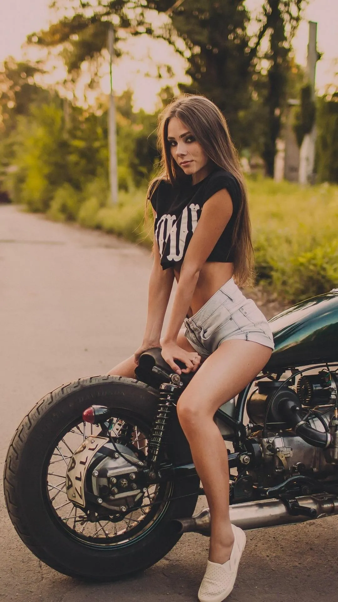 Stylish Woman Sitting on a Motorcycle in Summer Wallpaper