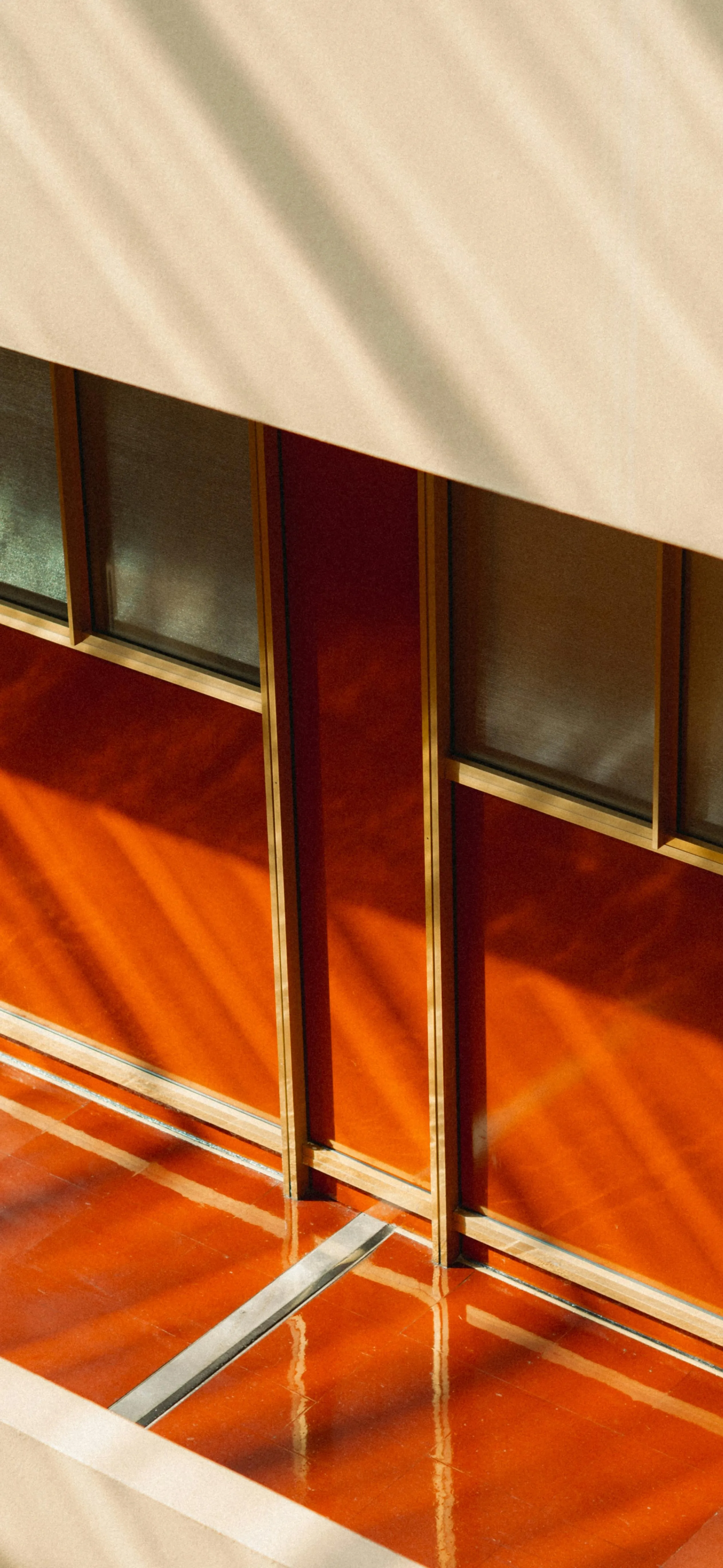 Sunlight Casting Shadows on Orange and Beige Modern Wall