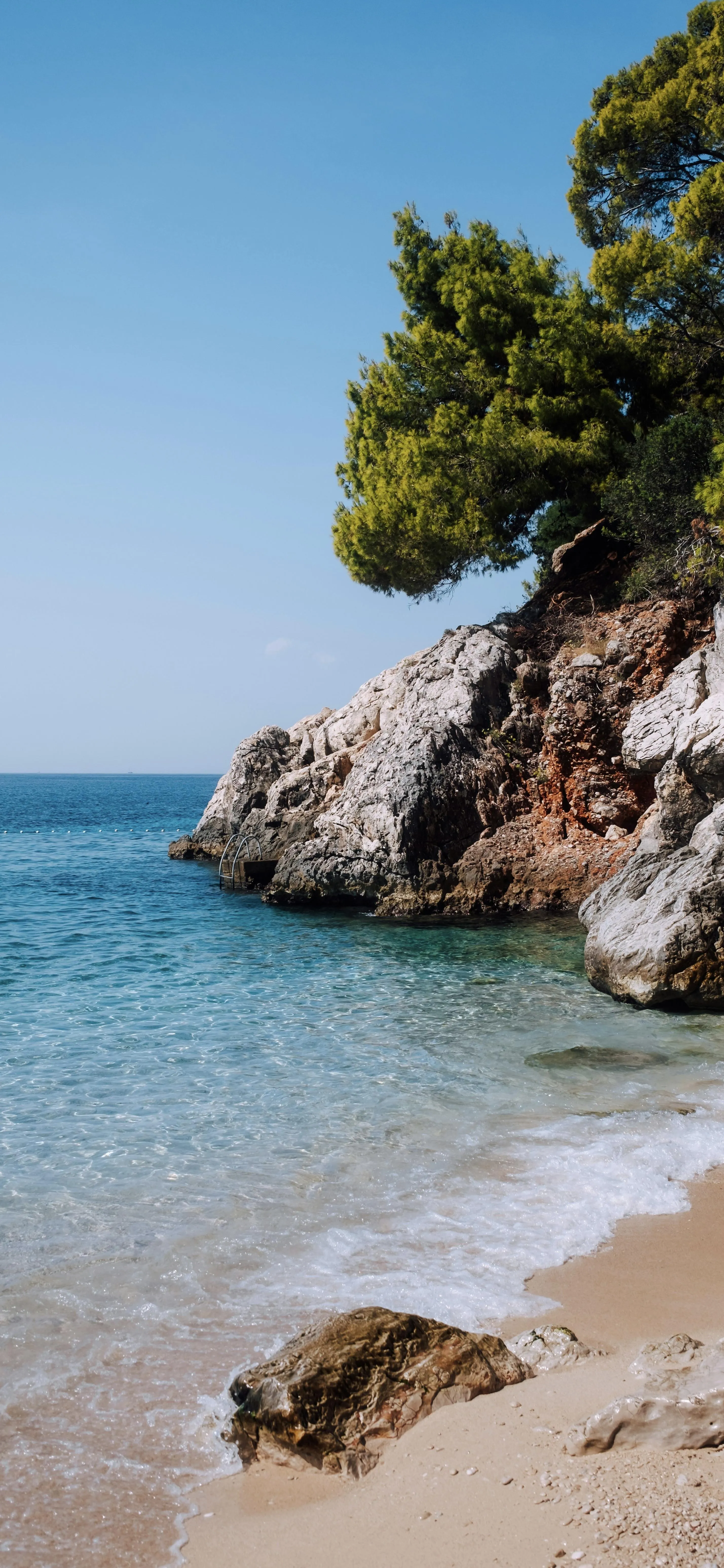 Sunny Beach with Crystal Water and Rocky Coastline Wallpaper