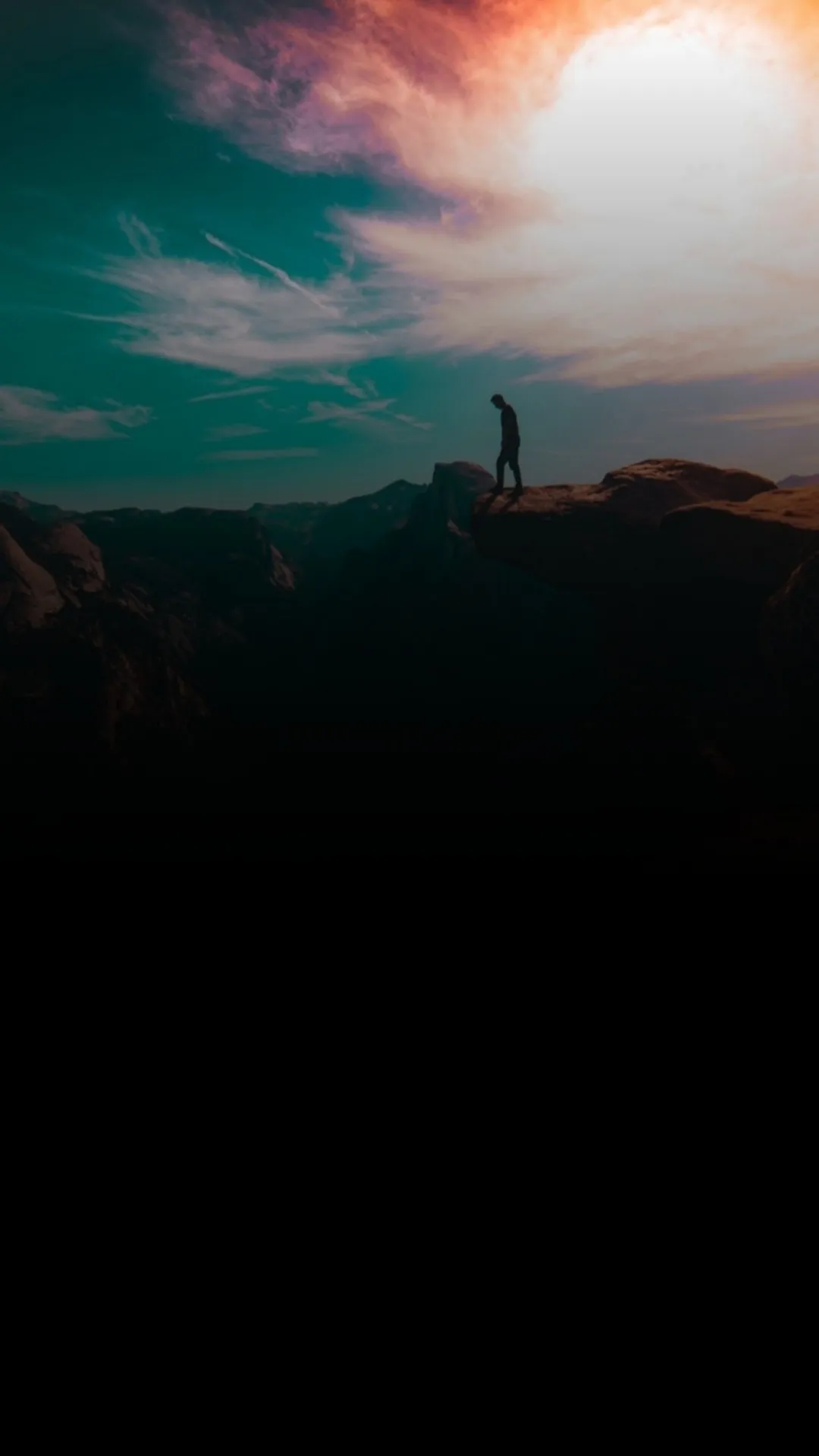 Sunset Behind Silhouetted Mountains and Clouds in Deep Orange