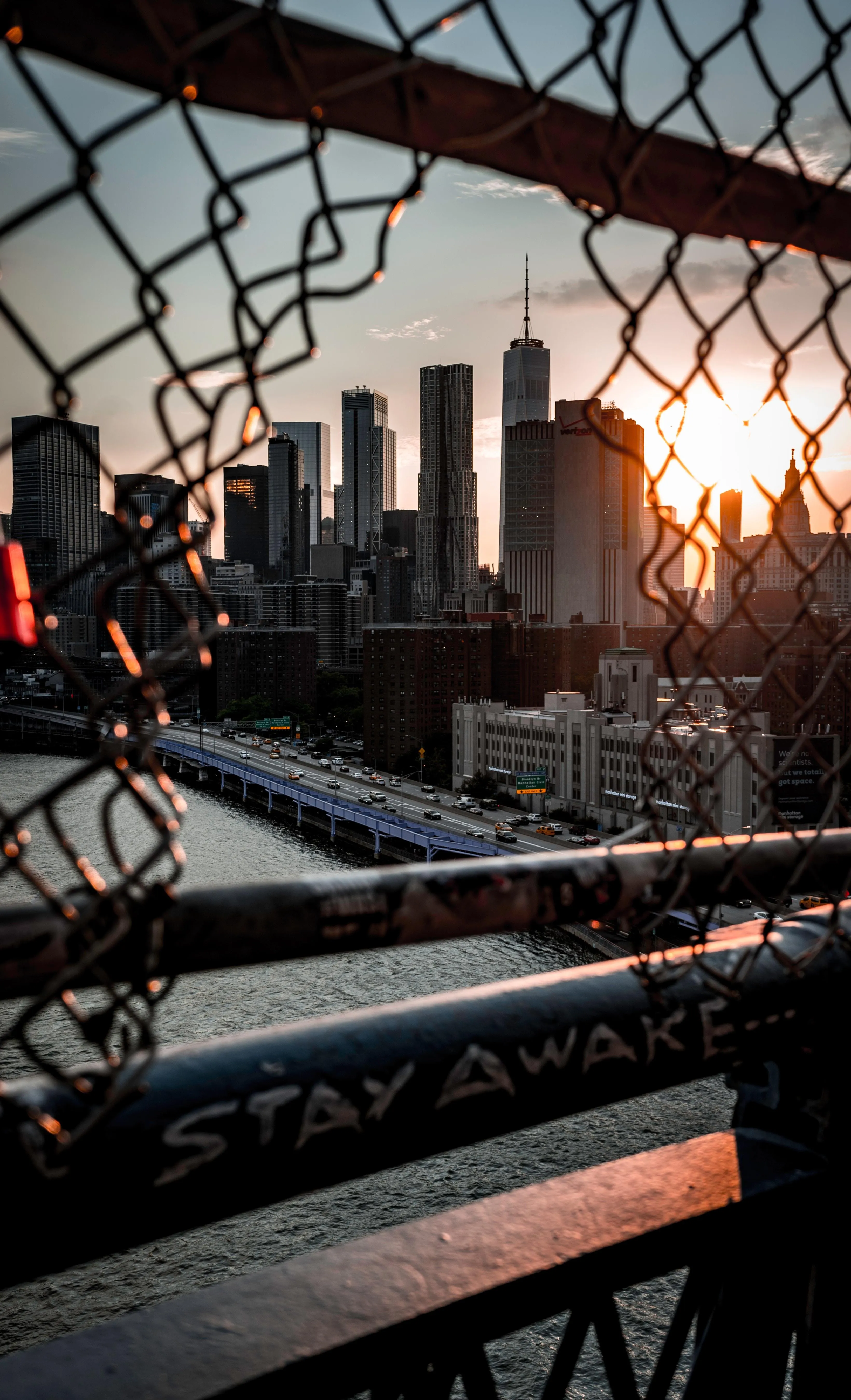 Sunset City Skyline Seen Through Chain Link Fence Wallpaper