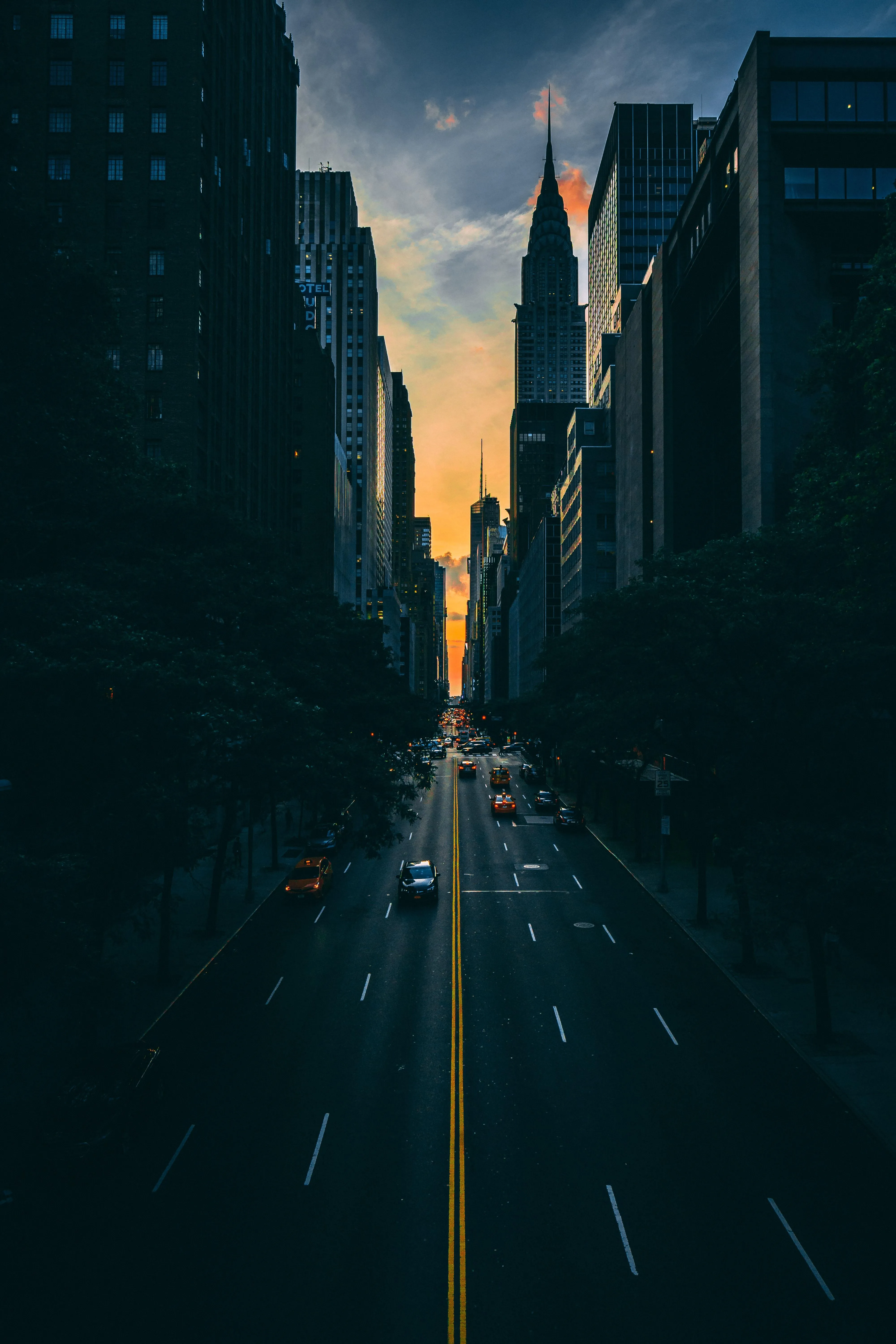 Sunset Illuminates Busy City Street with Tall Towers Image
