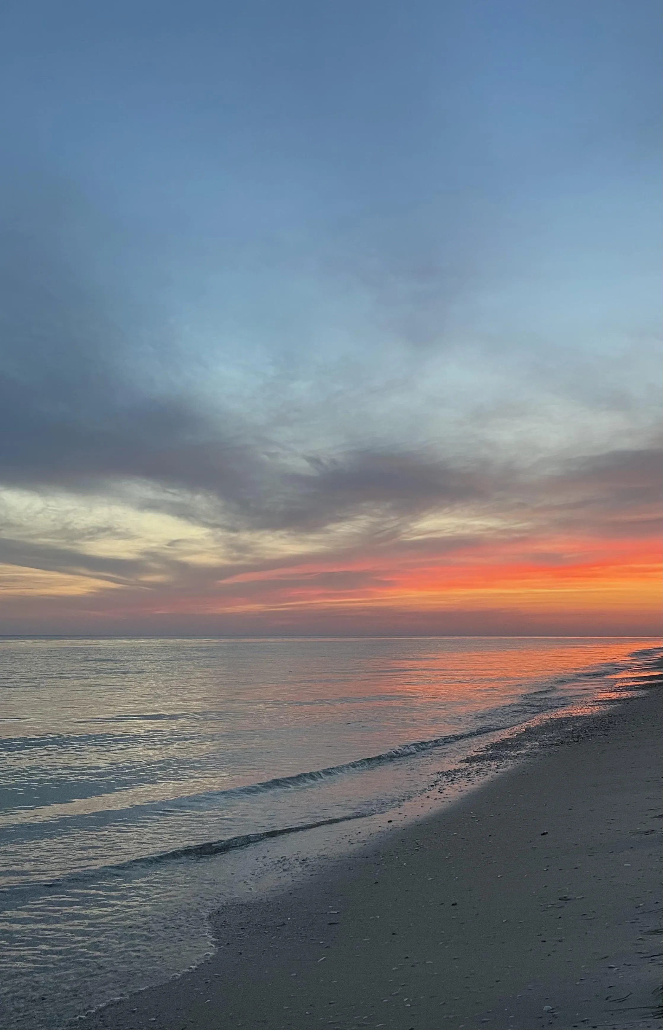 Sunset Sky with Dramatic Clouds Over Calm Ocean Water