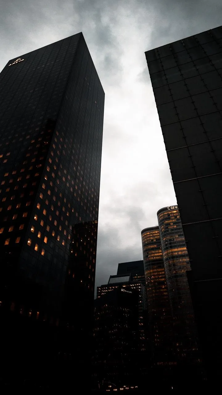 Tall City Buildings Reaching Toward Cloudy Sky View