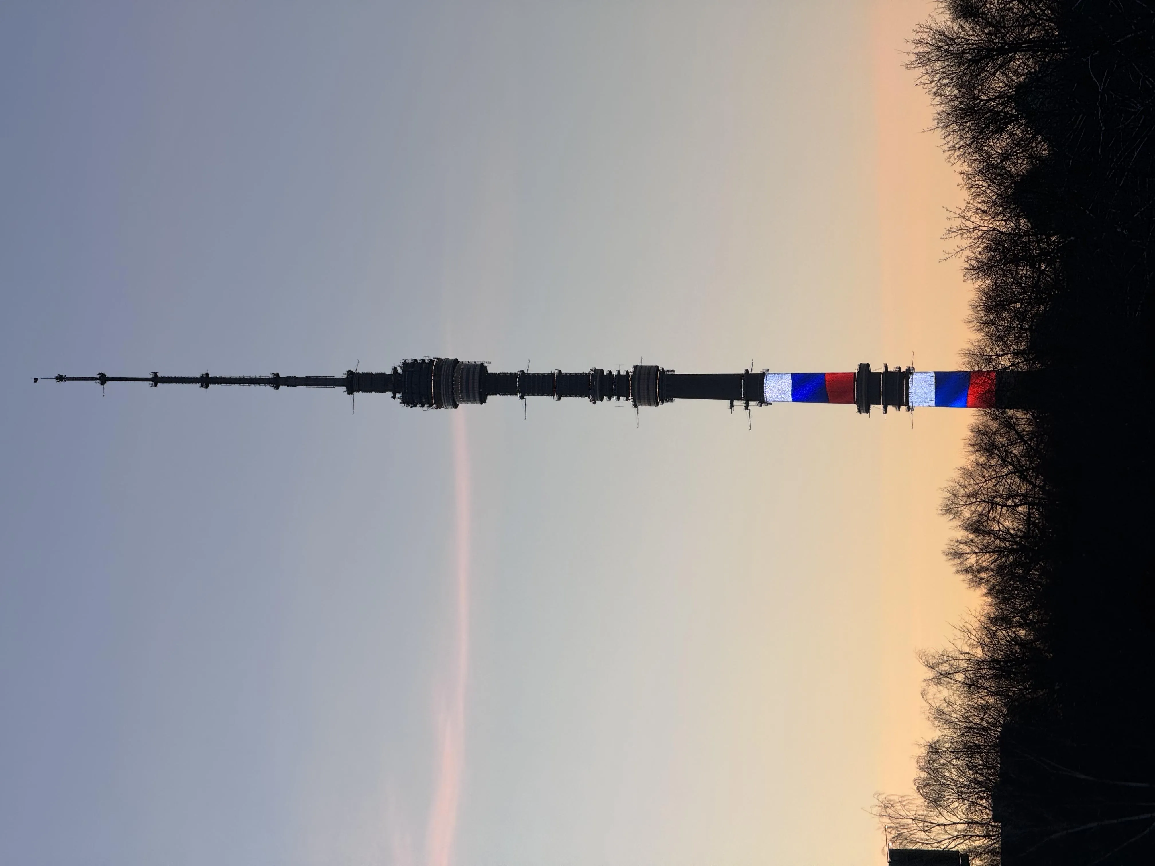 Tall Communication Tower at Sunset Against Clear Sky