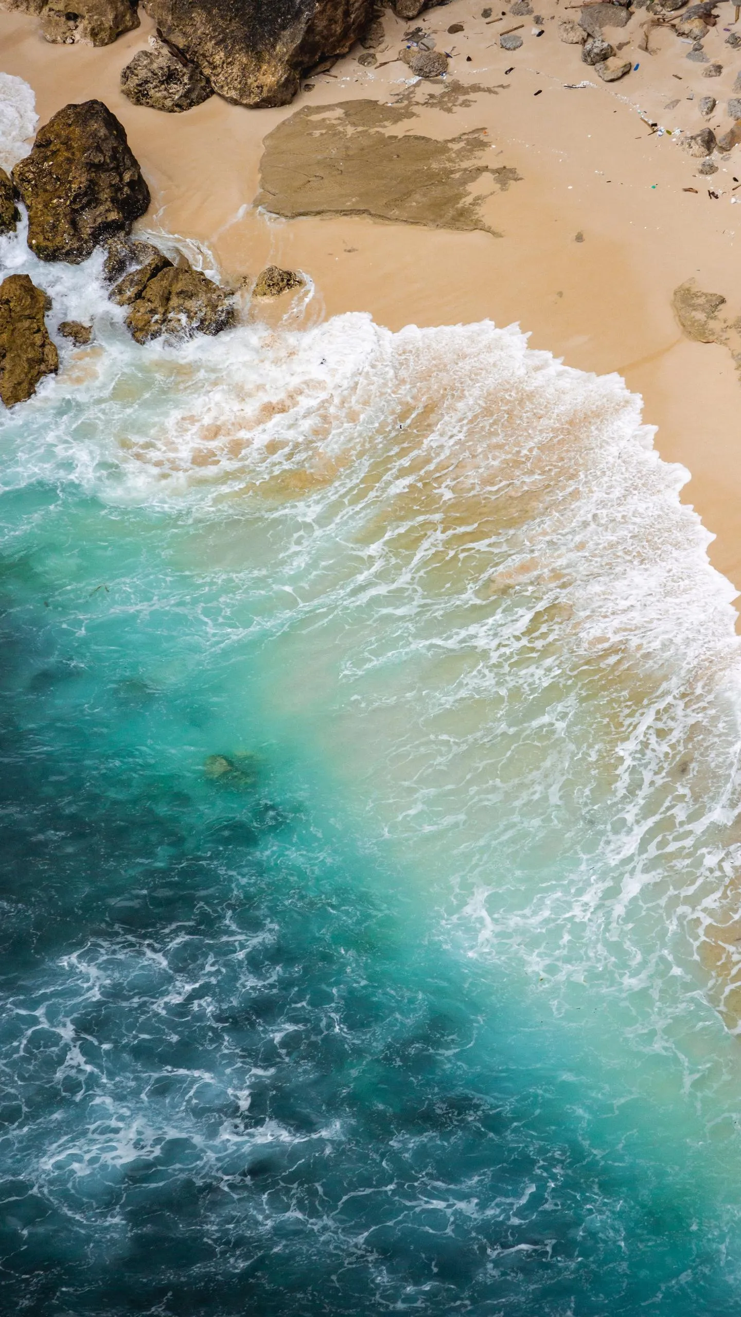 Top View of Ocean Waves Crashing on Sandy Beach Shore