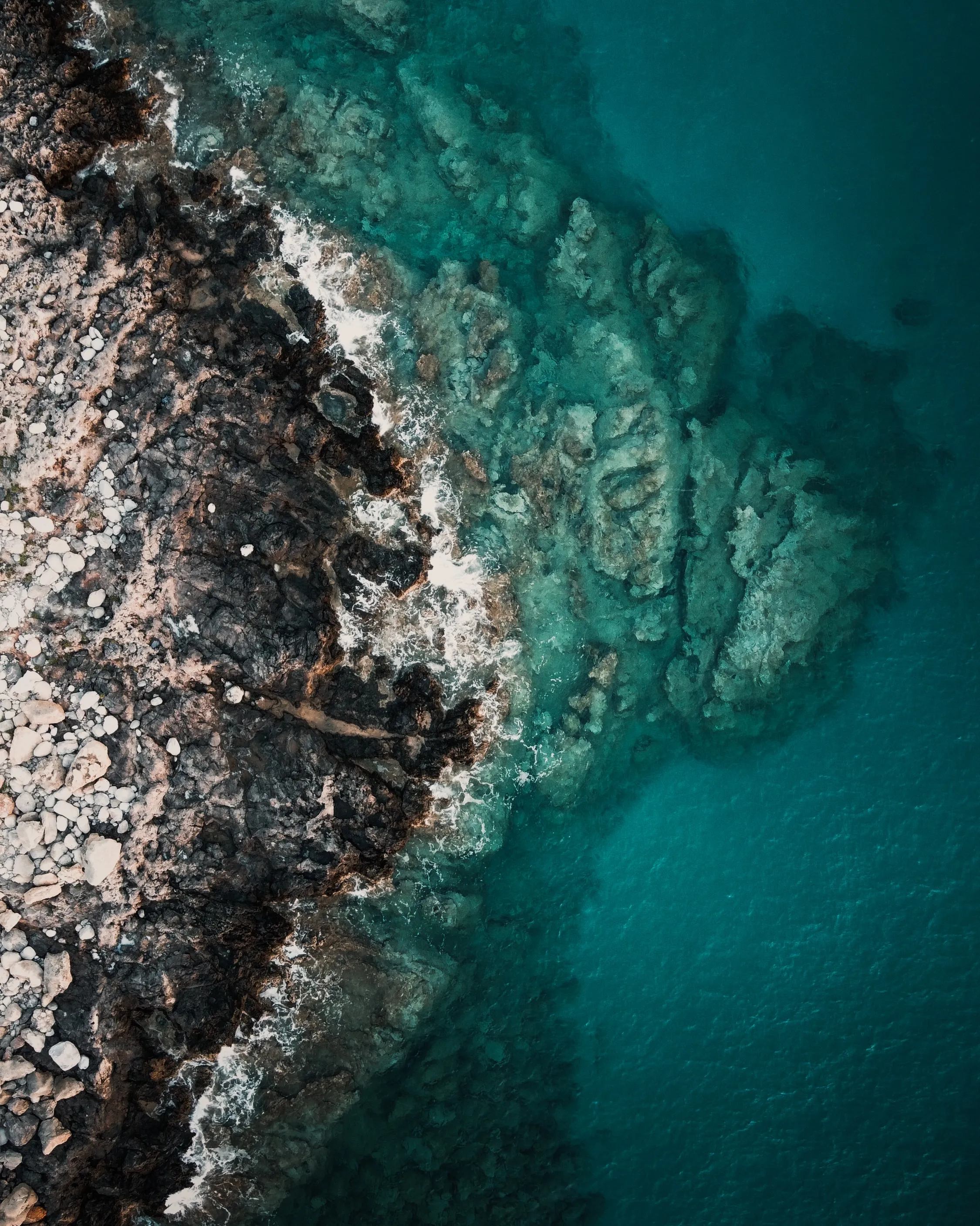 Top View of Rocky Coastline with Turquoise Sea Water