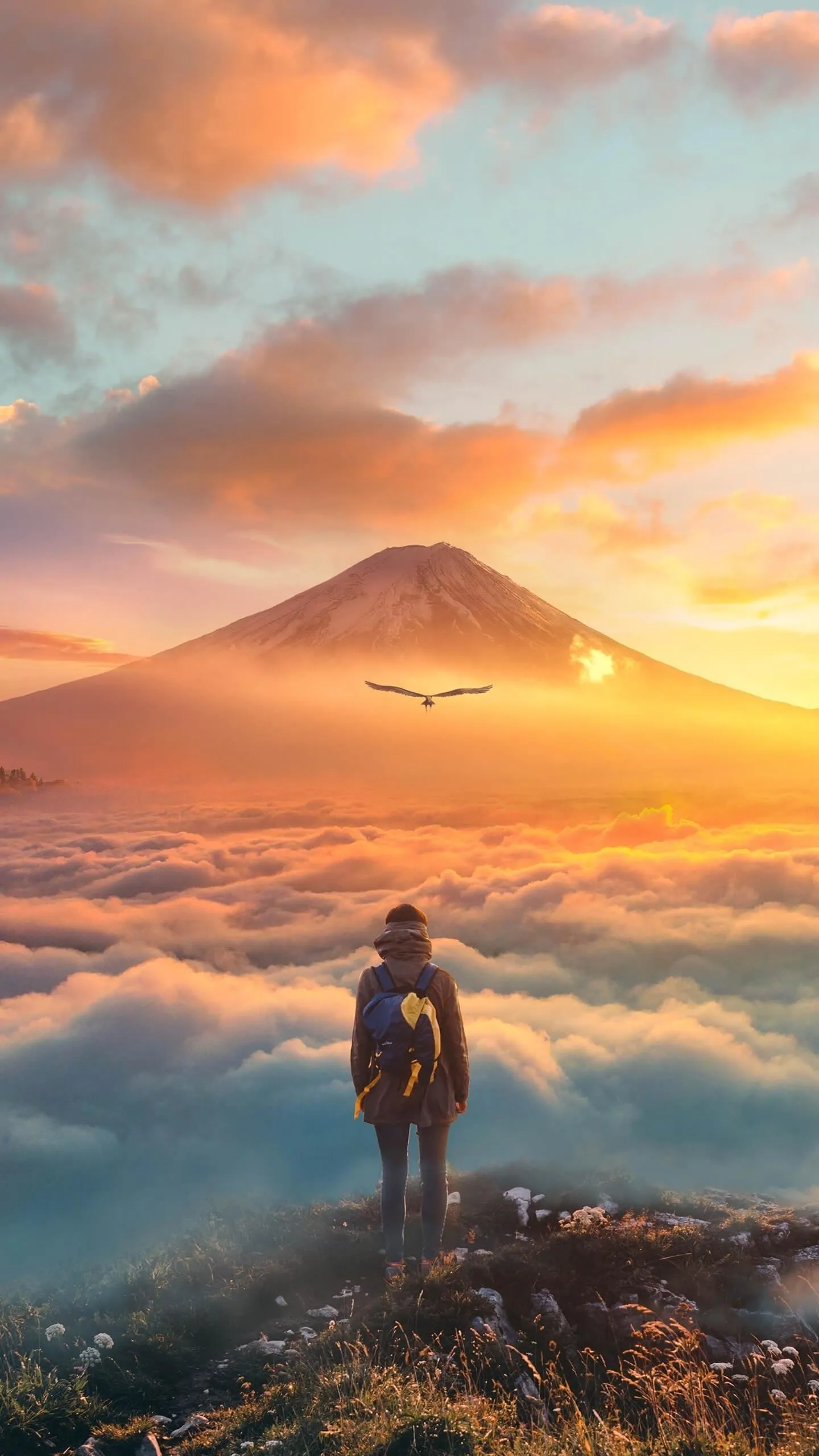 Traveler Standing on Cliff Facing Glowing Mountain Sunrise