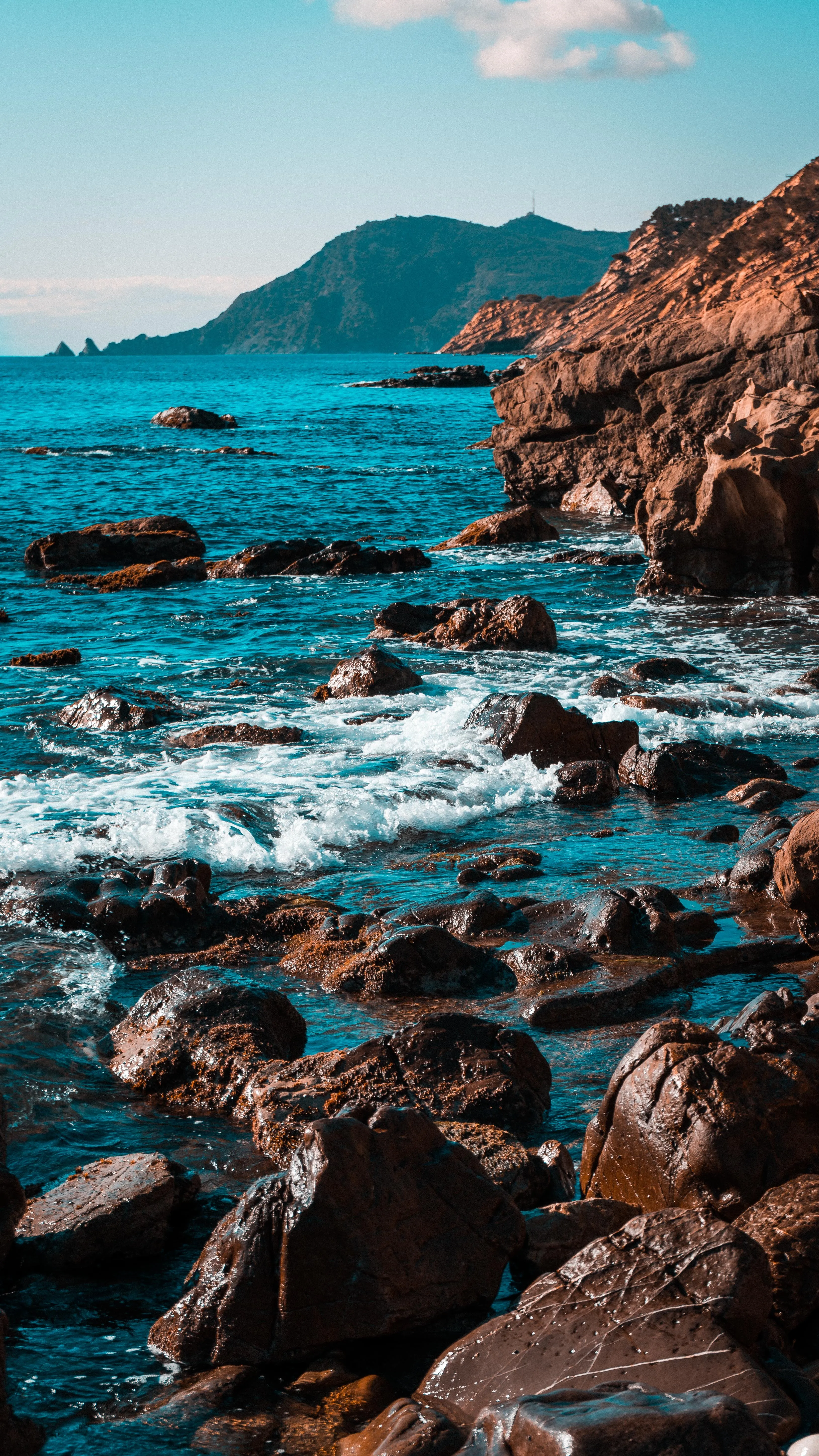 Turquoise Ocean Waves Crashing Against Rocky Cliffs