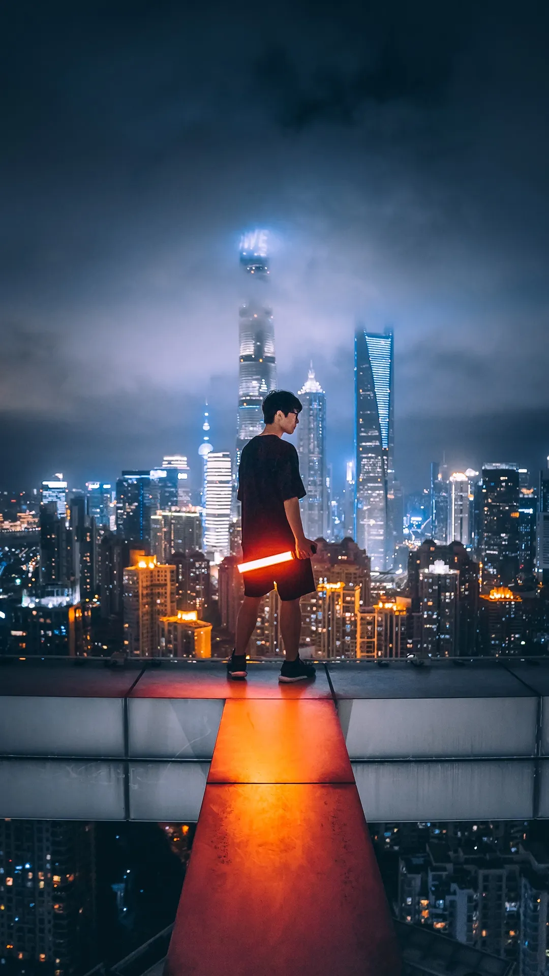 Urban Explorer Overlooks Futuristic City at Nighttime Glow