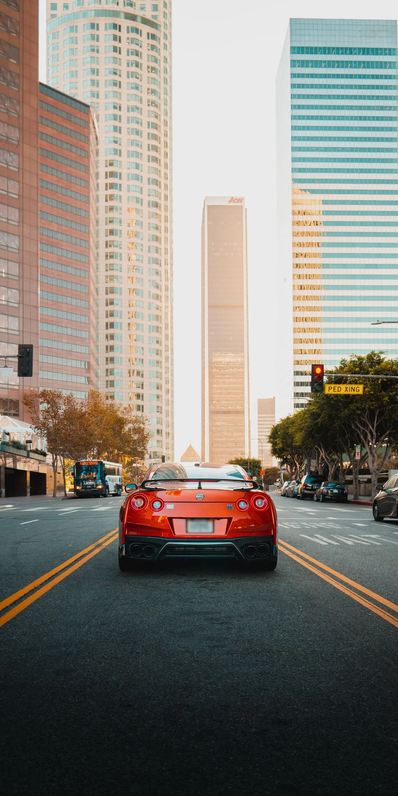 Urban Scene with Red Sports Car Driving Downtown Wallpaper