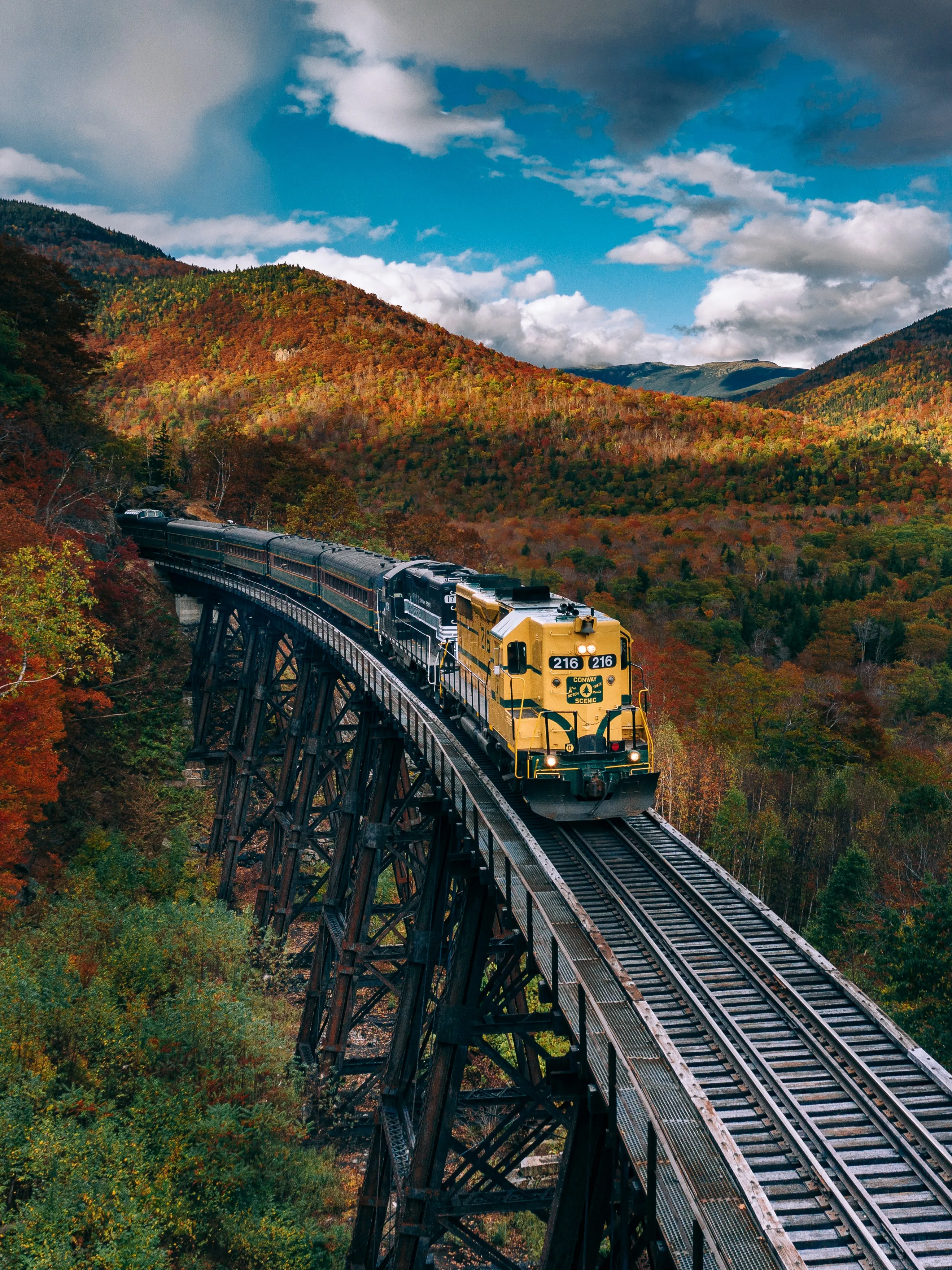 Wallpaper of Yellow Train Passing Through Mountain Landscape