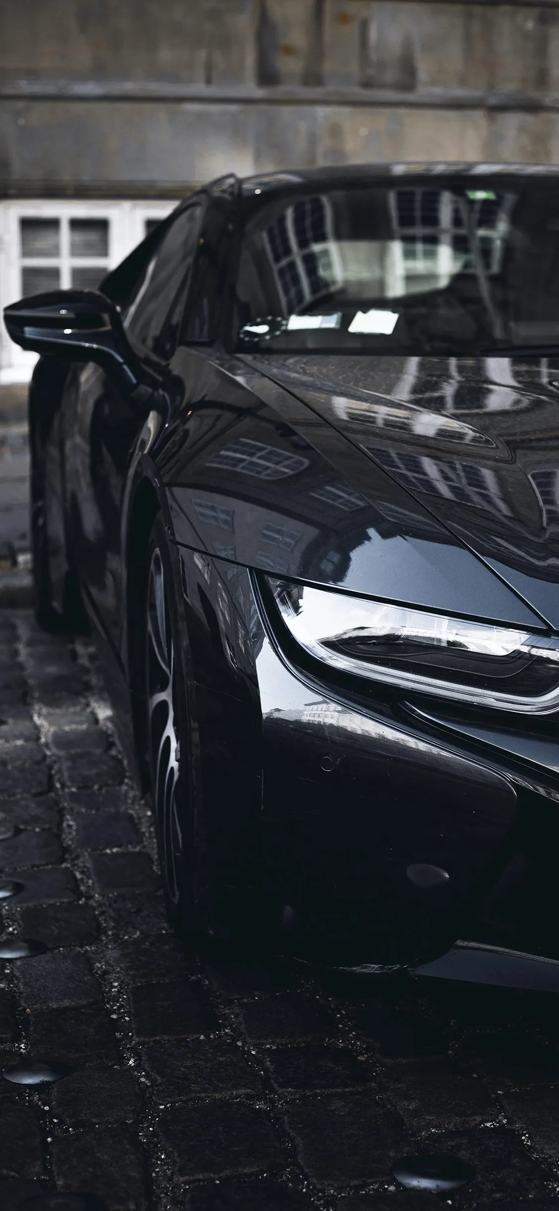 Wet Black Car Parked in Modern City Street Wallpaper