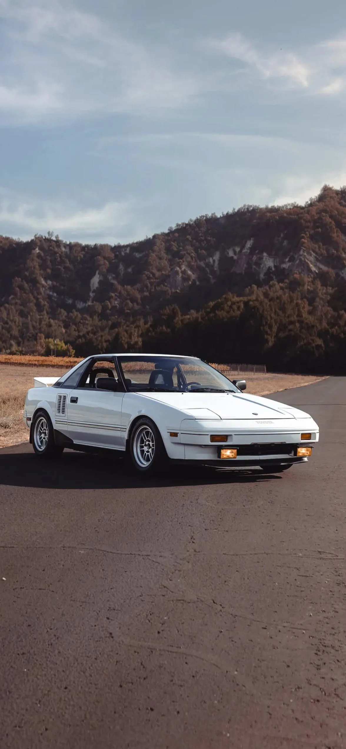 White Sports Car on Empty Road Near Mountains Wallpaper