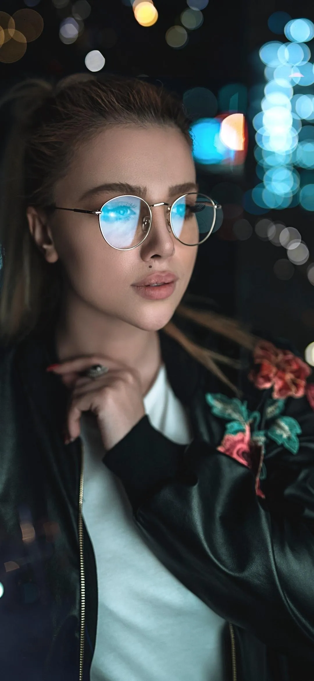 Woman with Glasses Under Neon Lights at Night Wallpaper