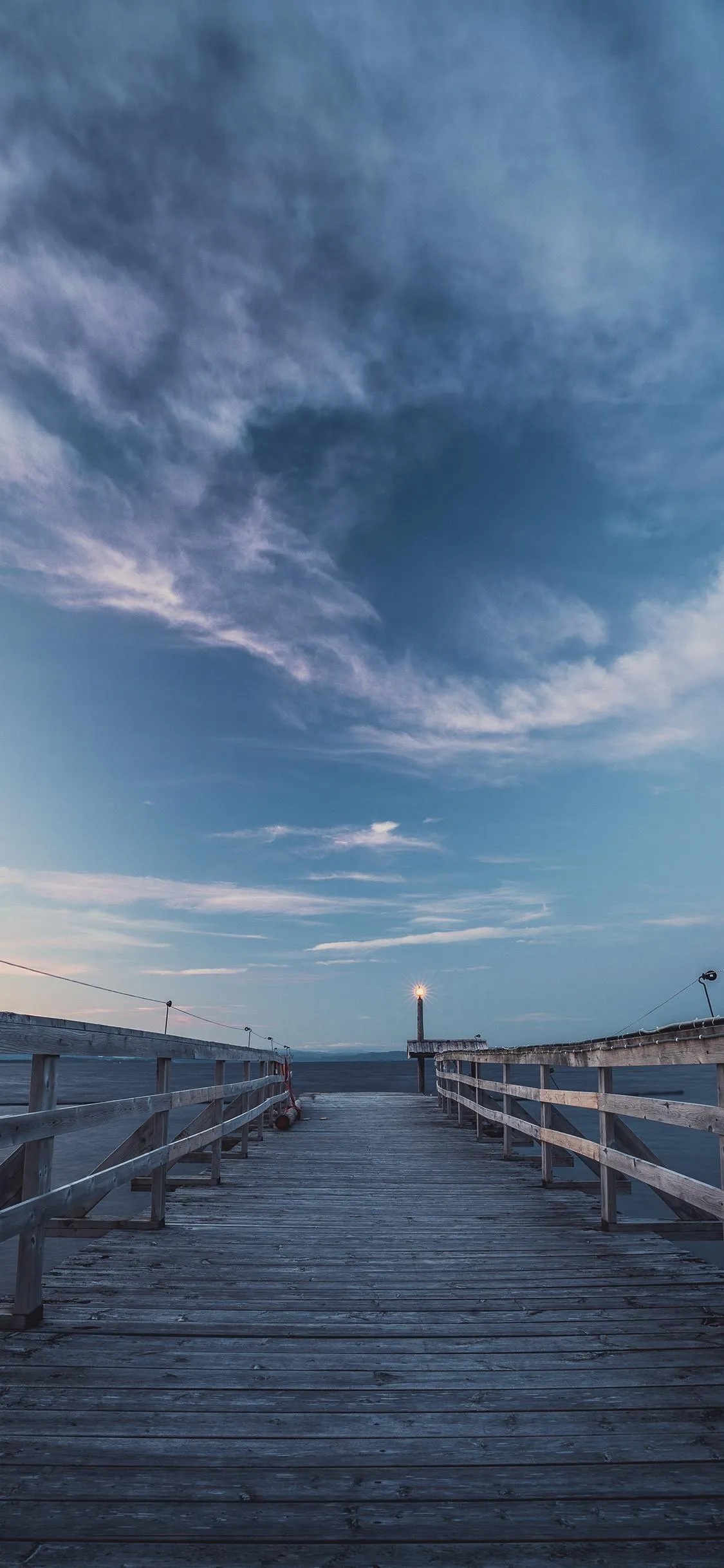 Wooden Pier Leading to Ocean Under Cloudy Sky Wallpaper