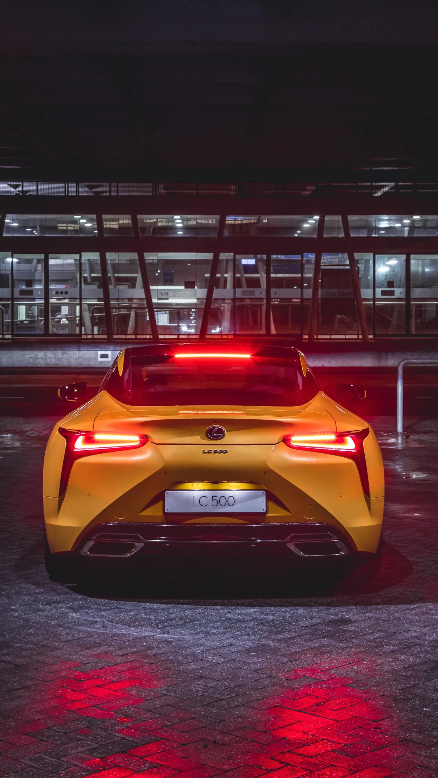 Yellow Sports Car with Tail Lights in a Night Setting
