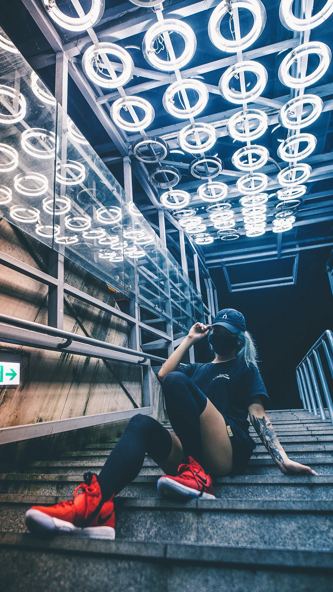 Young Girl Sitting on Steps with Bright Urban Lighting