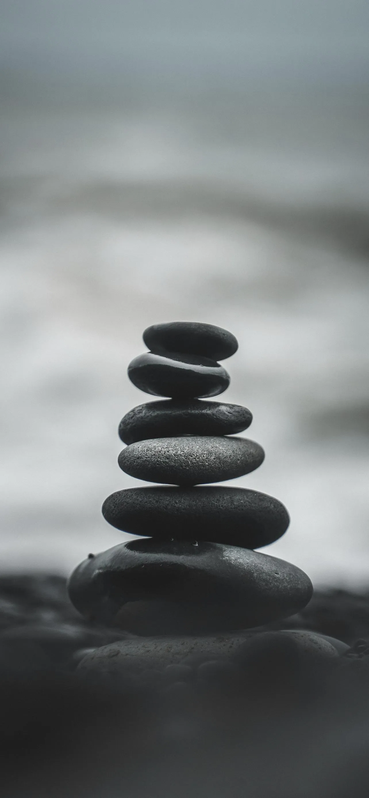 Zen Balance of Black Stones in Calm Monochrome Water Scene