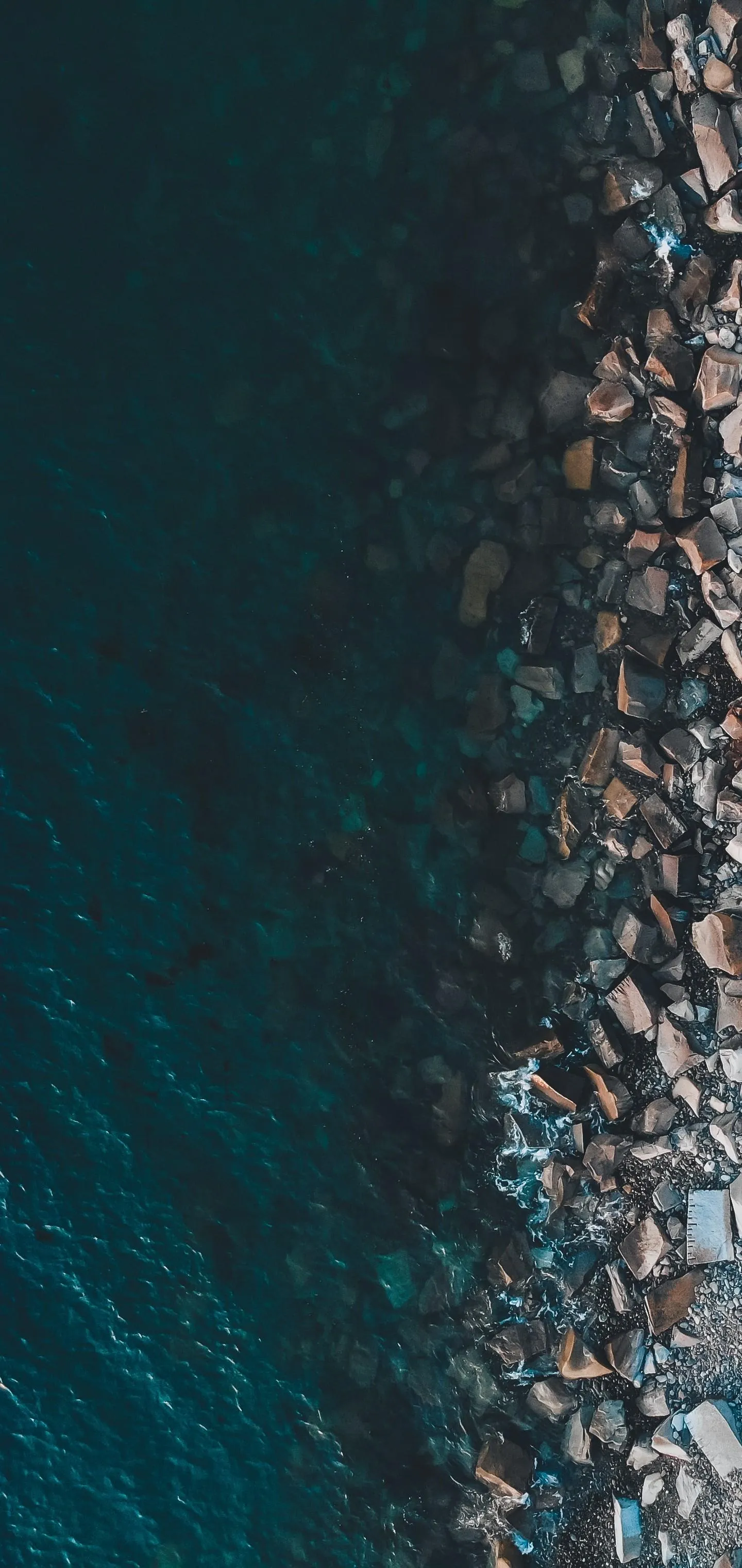 Aerial View of Ocean Waves Crashing on Rocky Shore