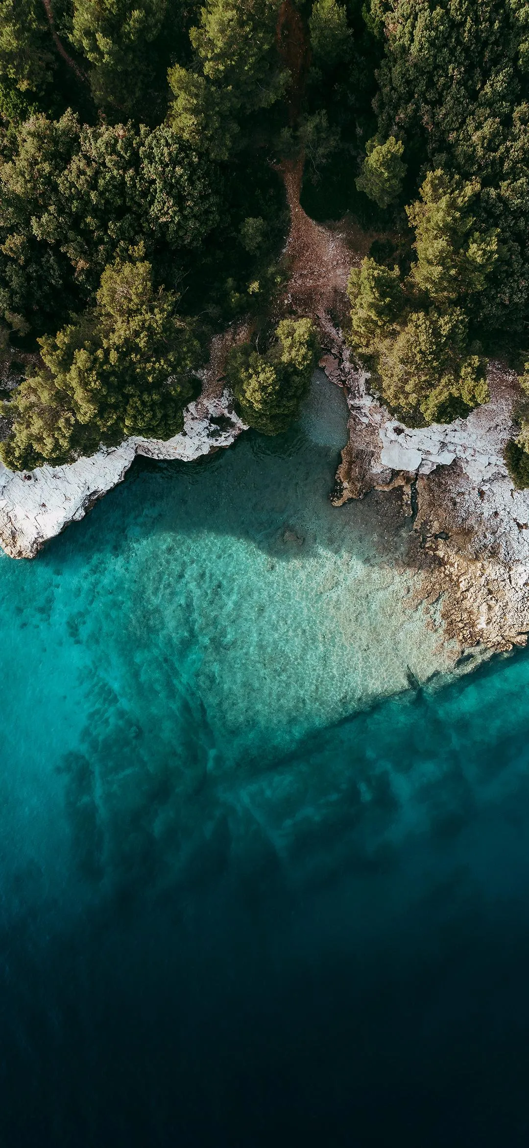 Aerial View of Turquoise Water Crashing Against Rocky Shore