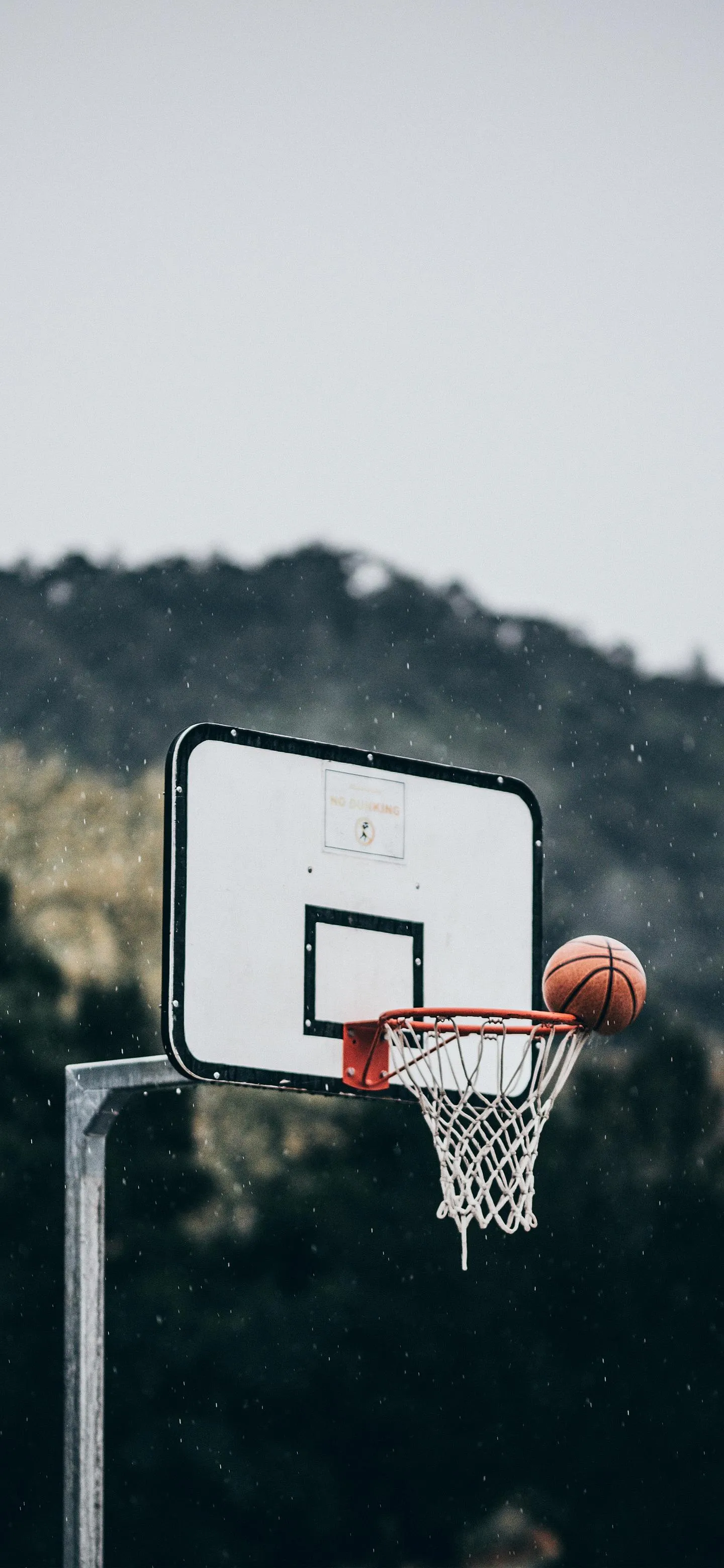 Basketball Hoop in a Foggy Outdoor Mountain Court Wallpaper