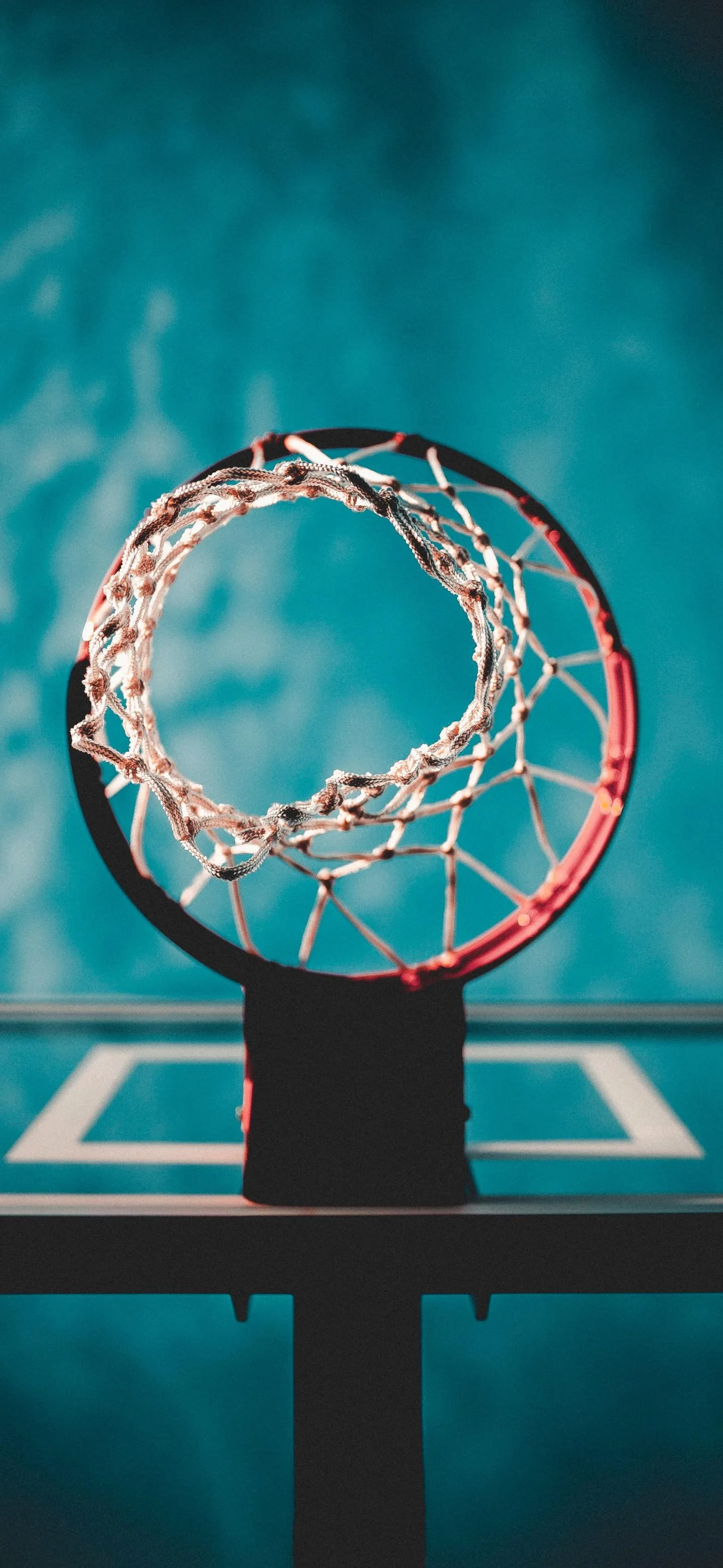 Basketball hoop with net against a blue background Wallpaper