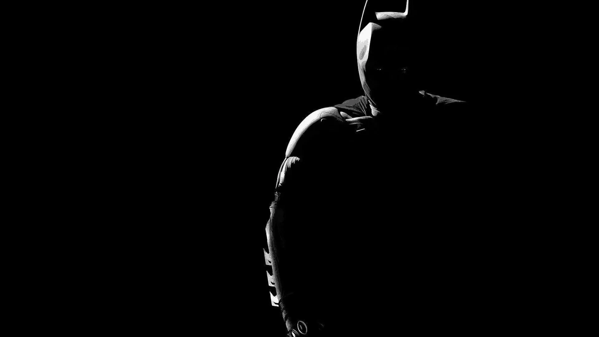 Batman standing in dramatic black shadow lighting Wallpaper