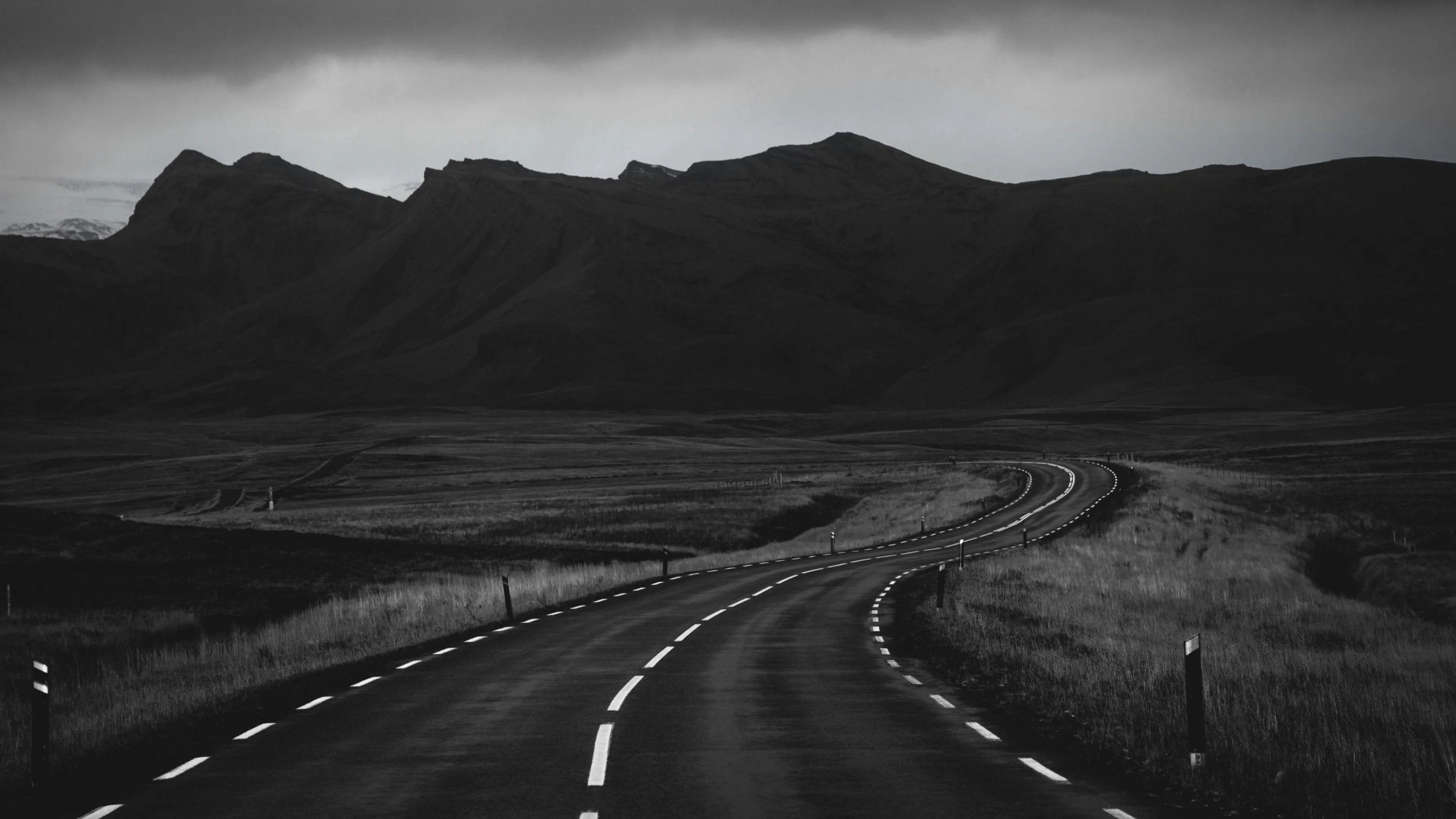 Black and white photo of winding road in a mountainous area