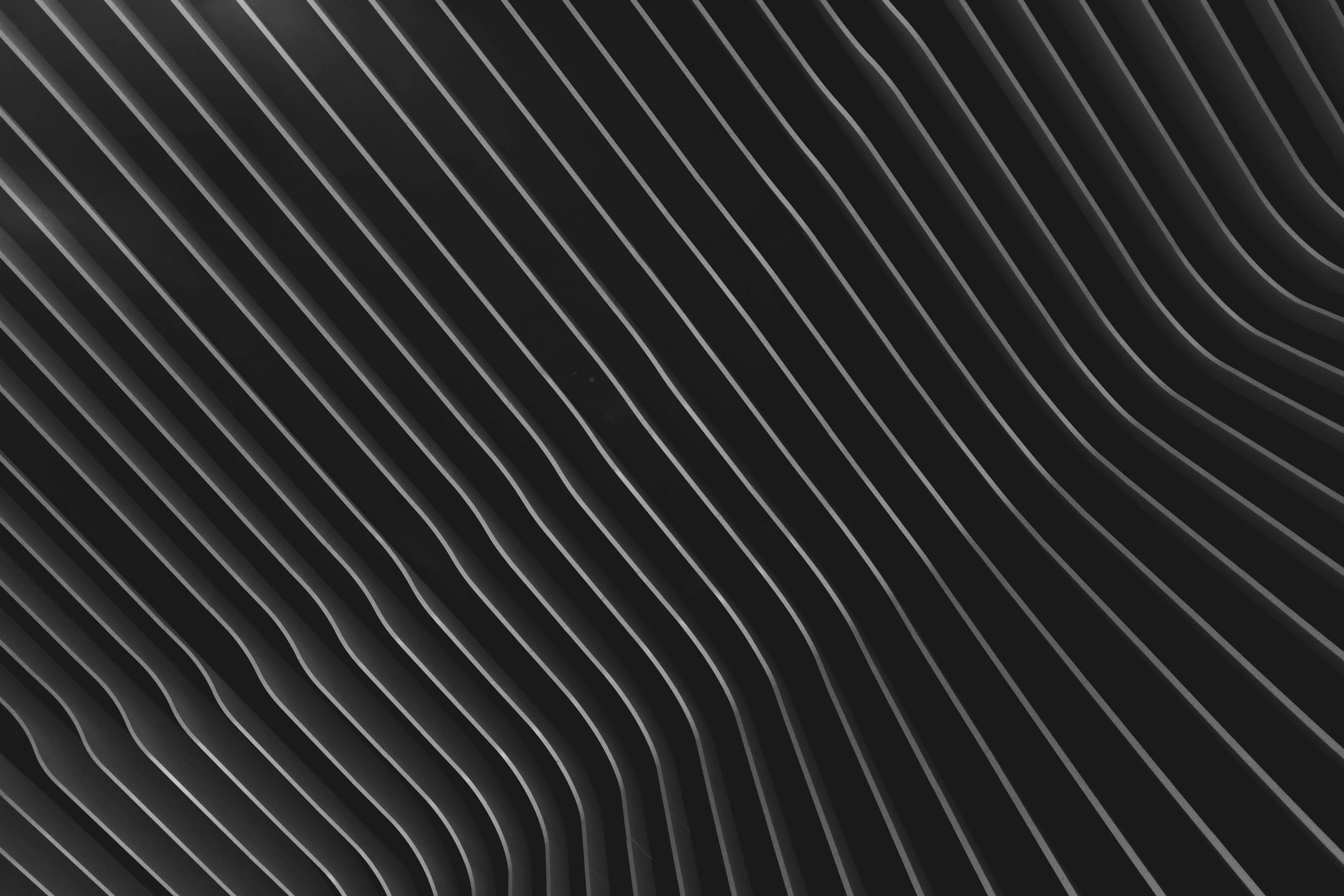 Black background with diagonal curved white lines Wallpaper
