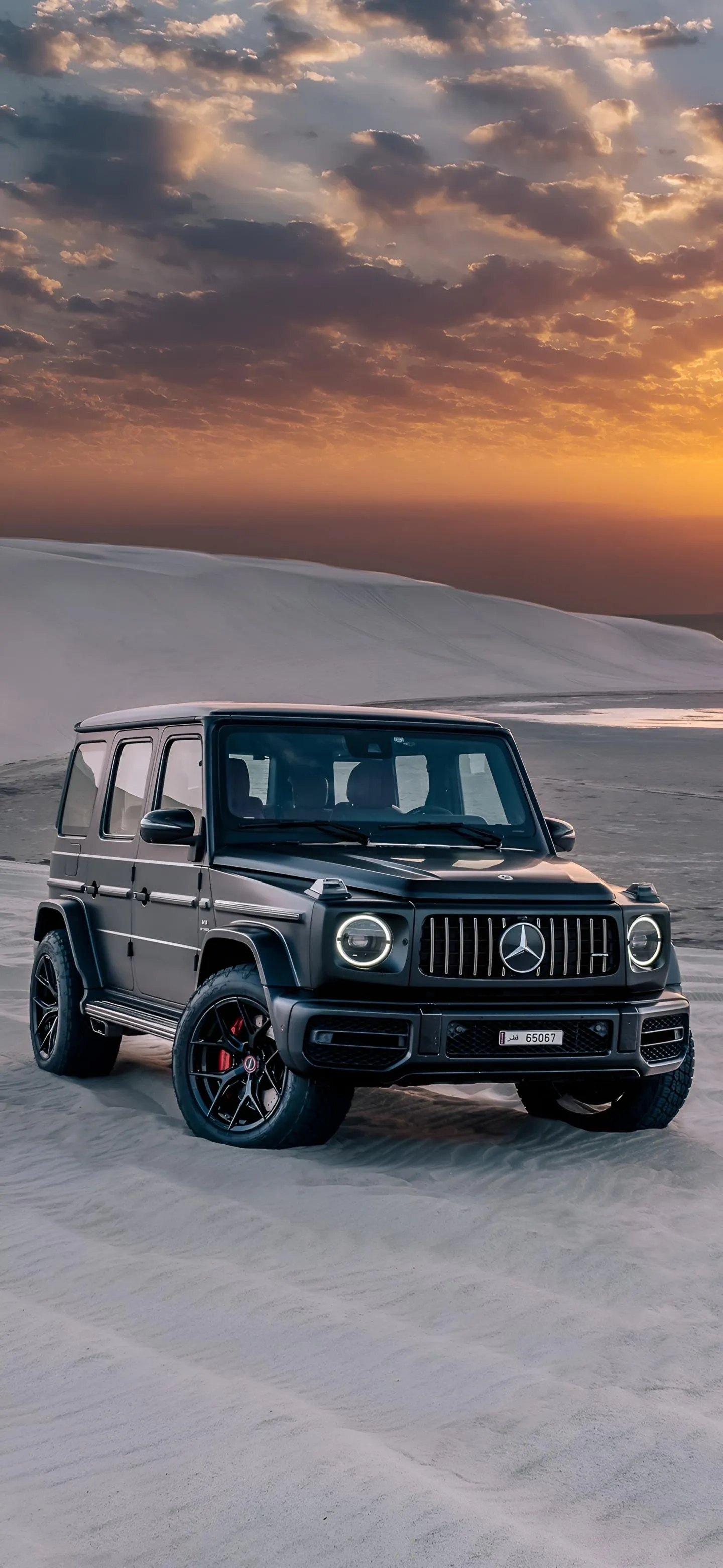 Black Jeep Driving on Sandy Desert at Sunset Wallpaper