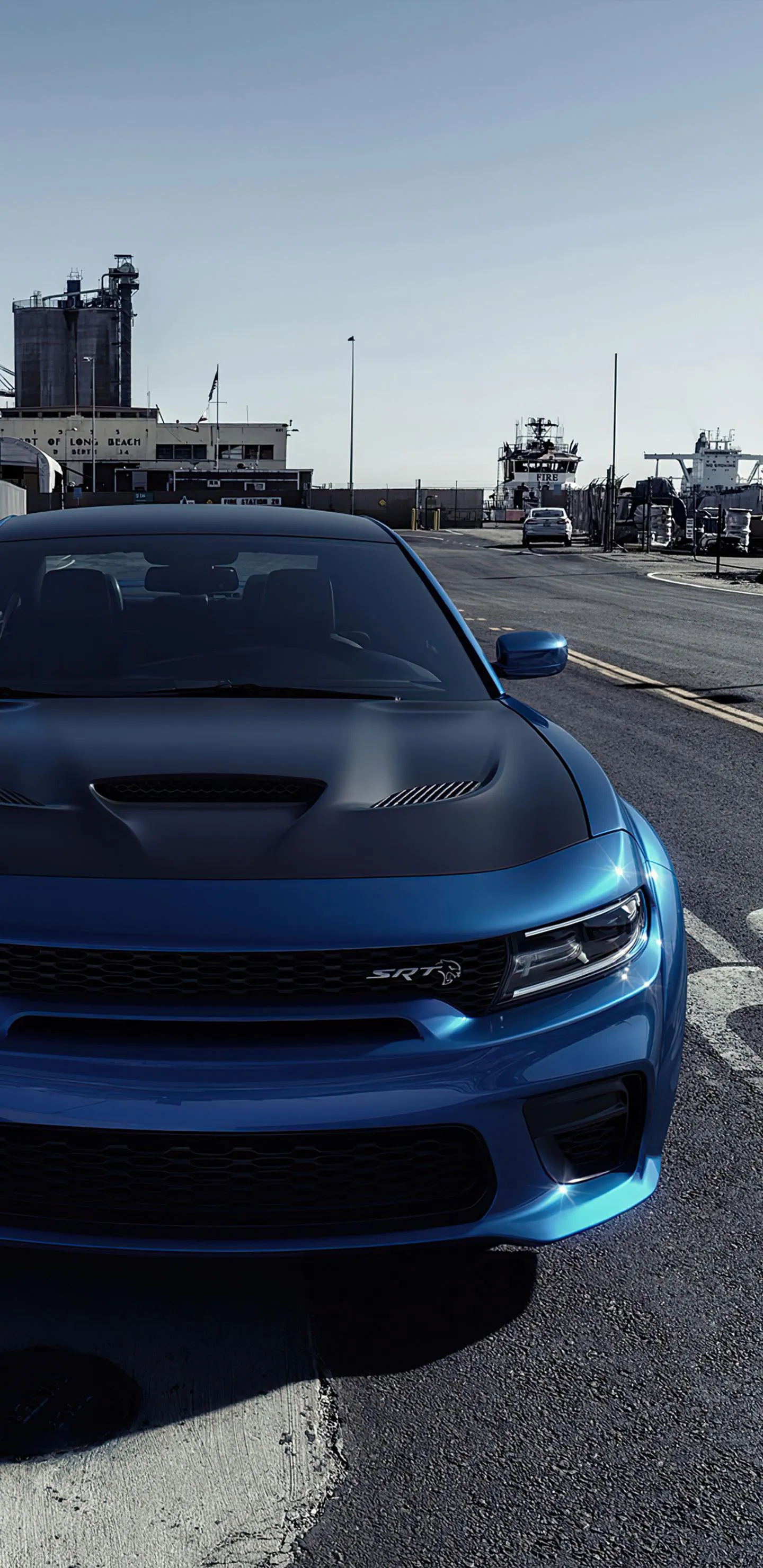 Blue Sports Car Parked on Road with Cityscape Background Mobile