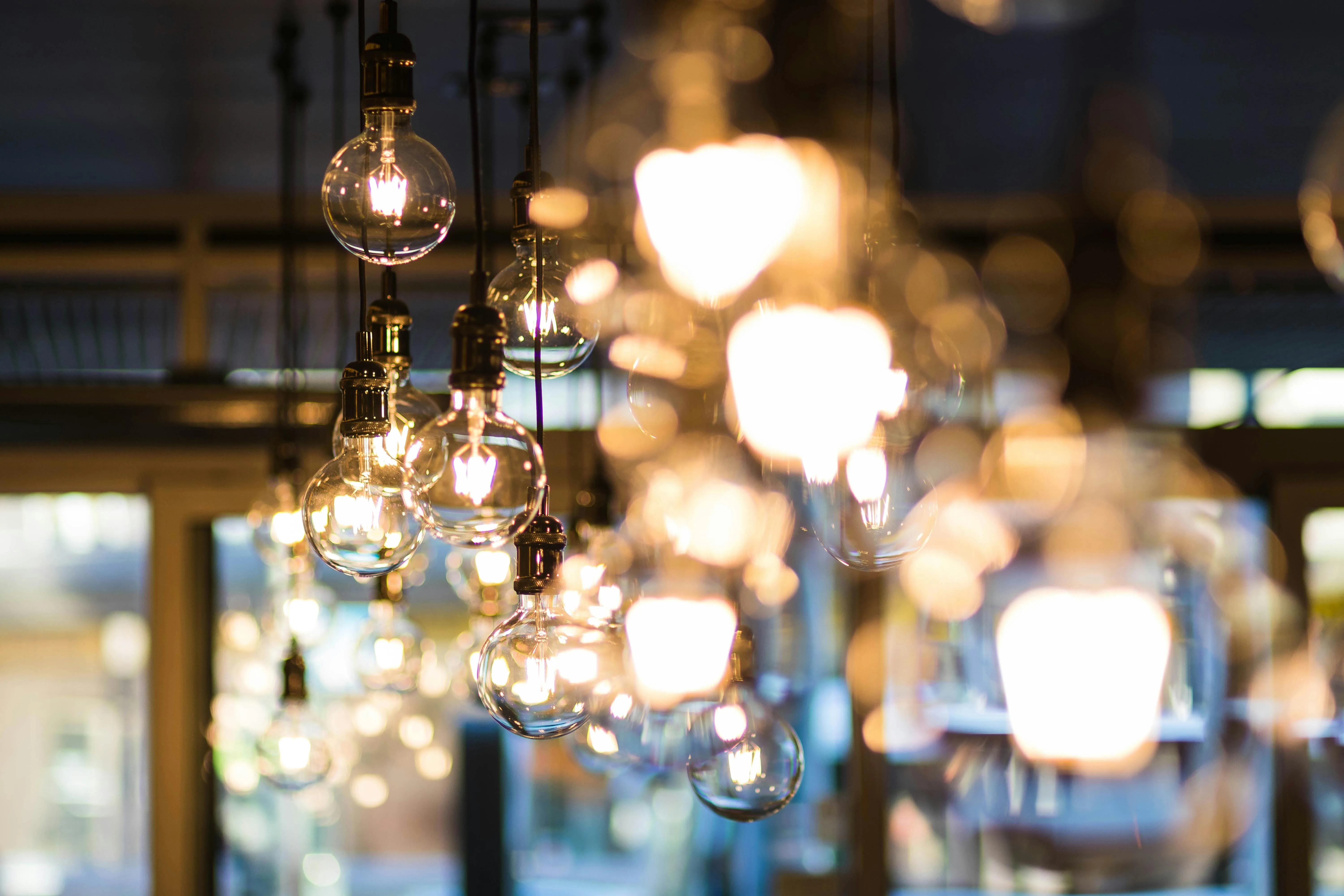 Blurred background of warm hanging light bulbs in a cafe