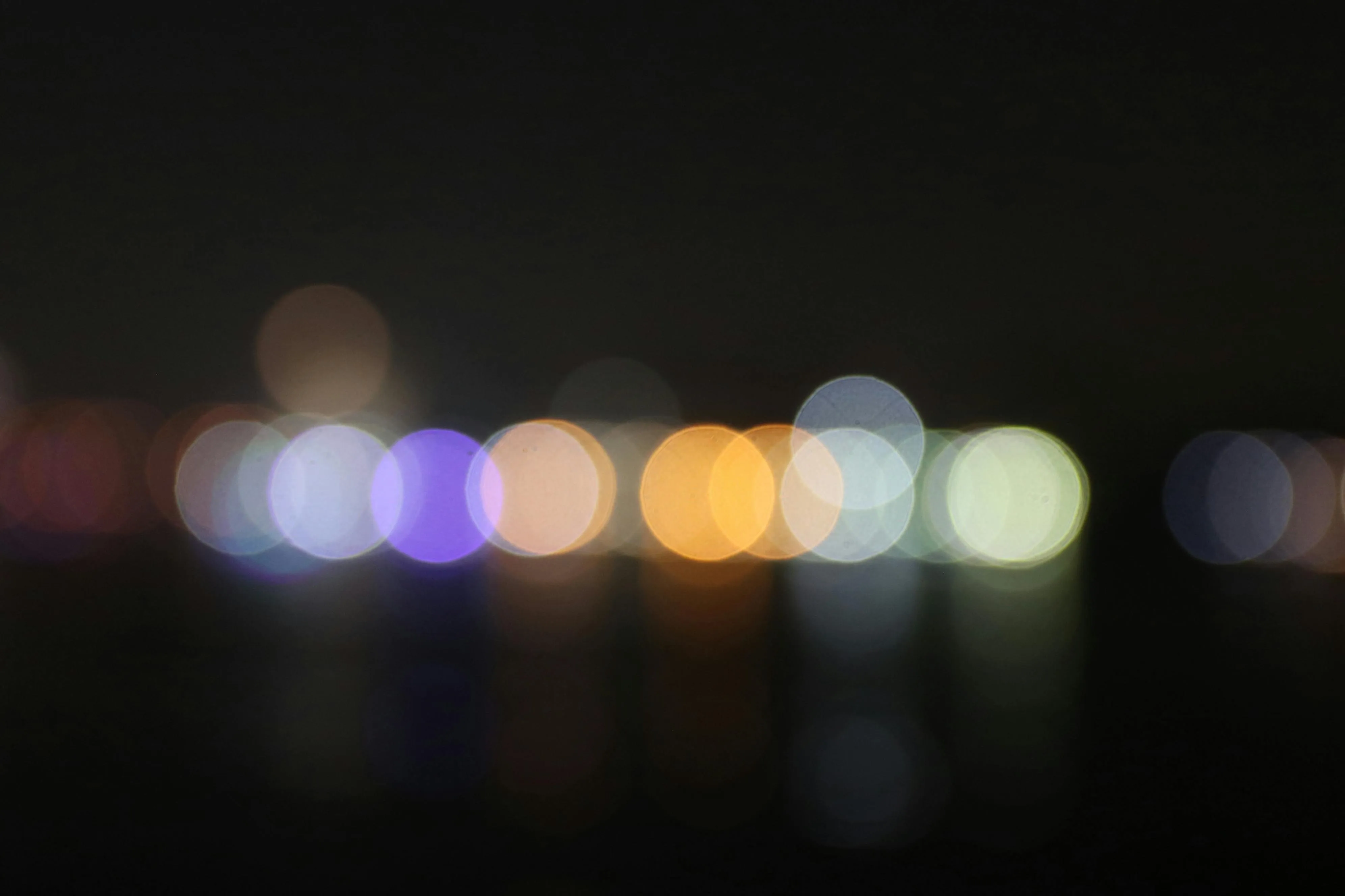 Blurred city lights on black background with soft bokeh glow