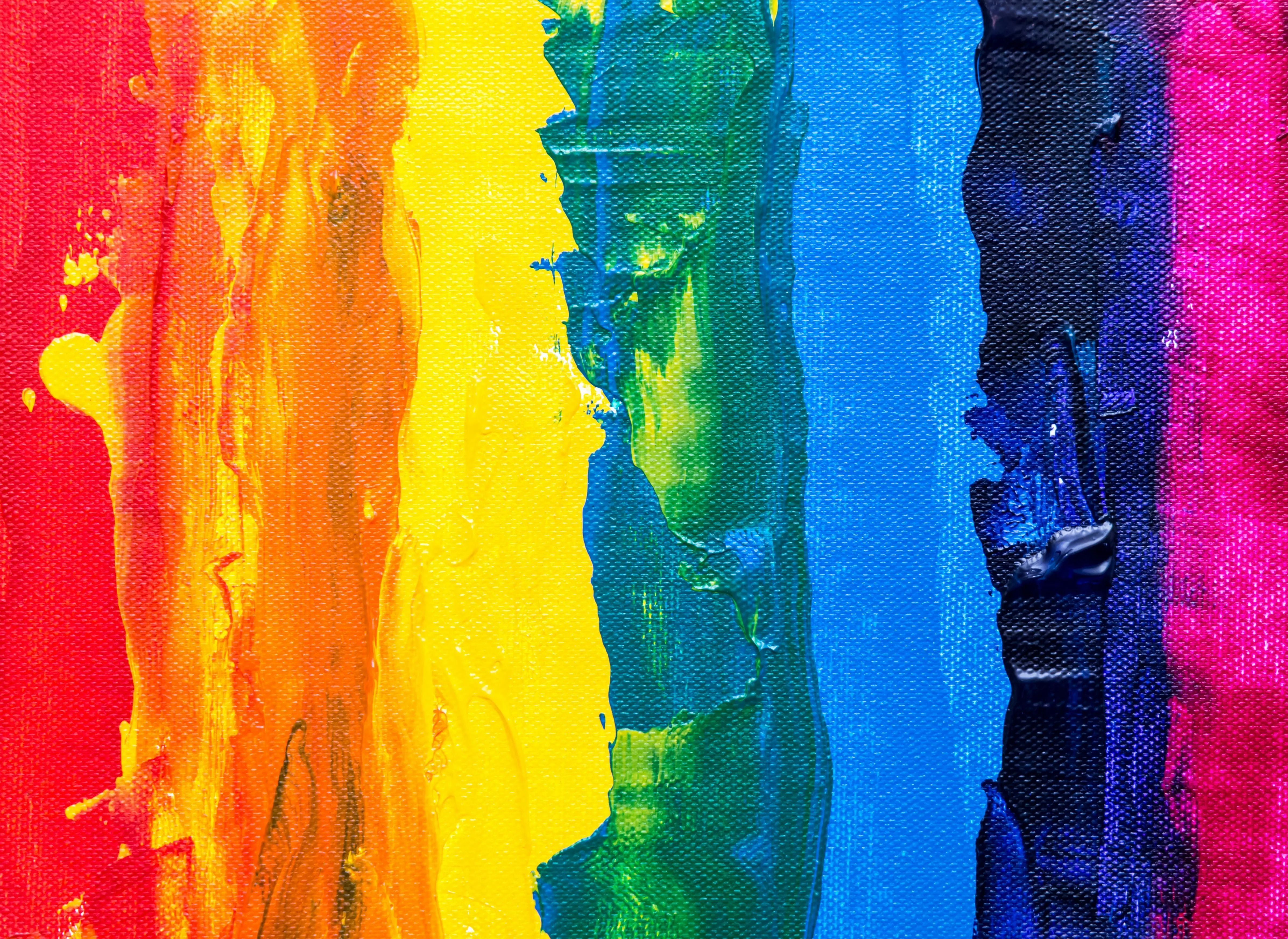 Bold rainbow paint strokes on textured canvas background